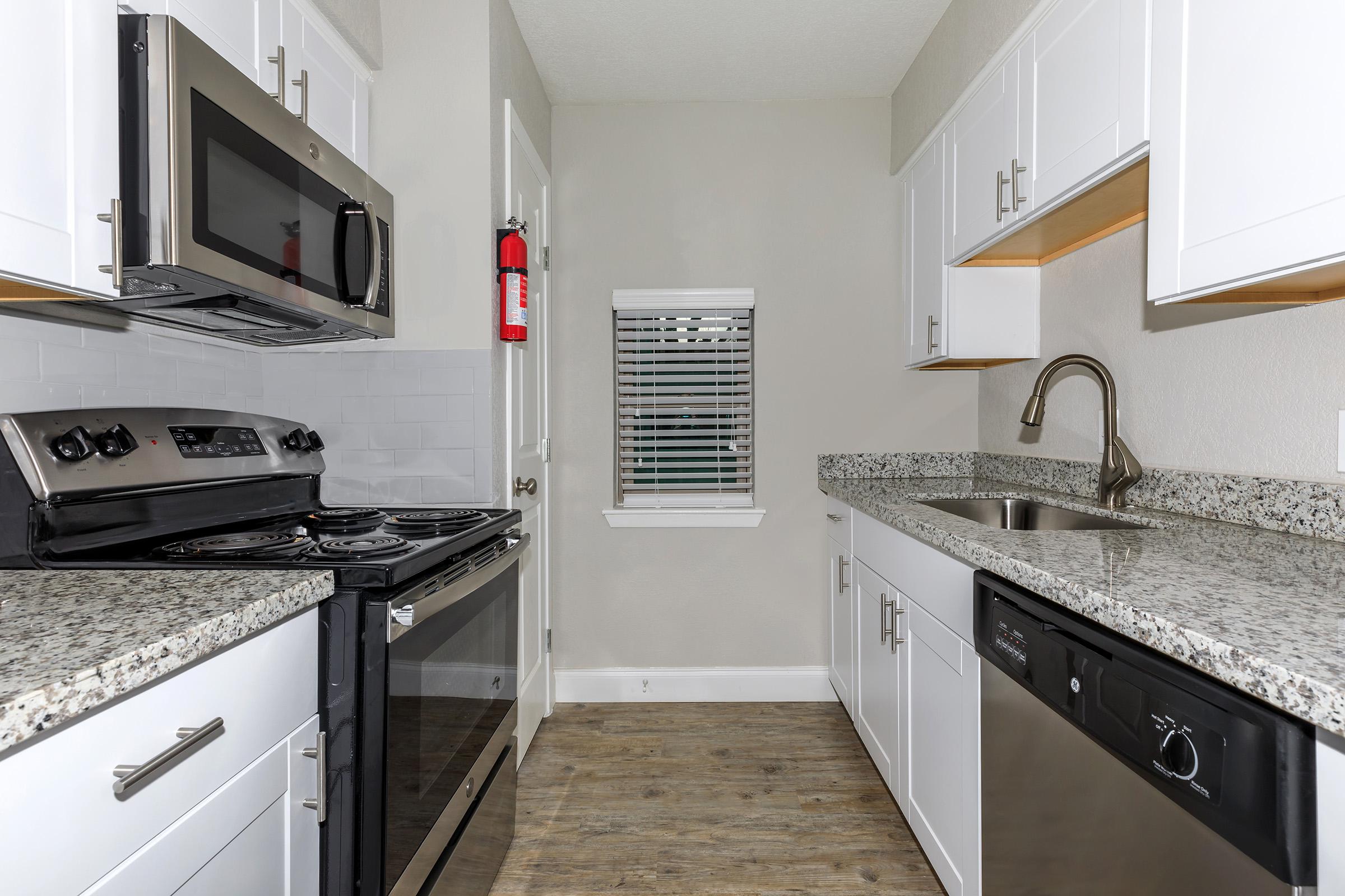 a kitchen with a stove a sink and a microwave