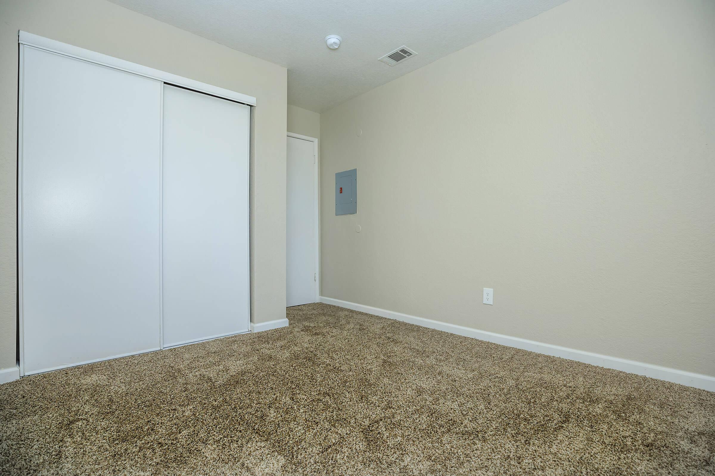 Vacant bedroom with closed closet doors