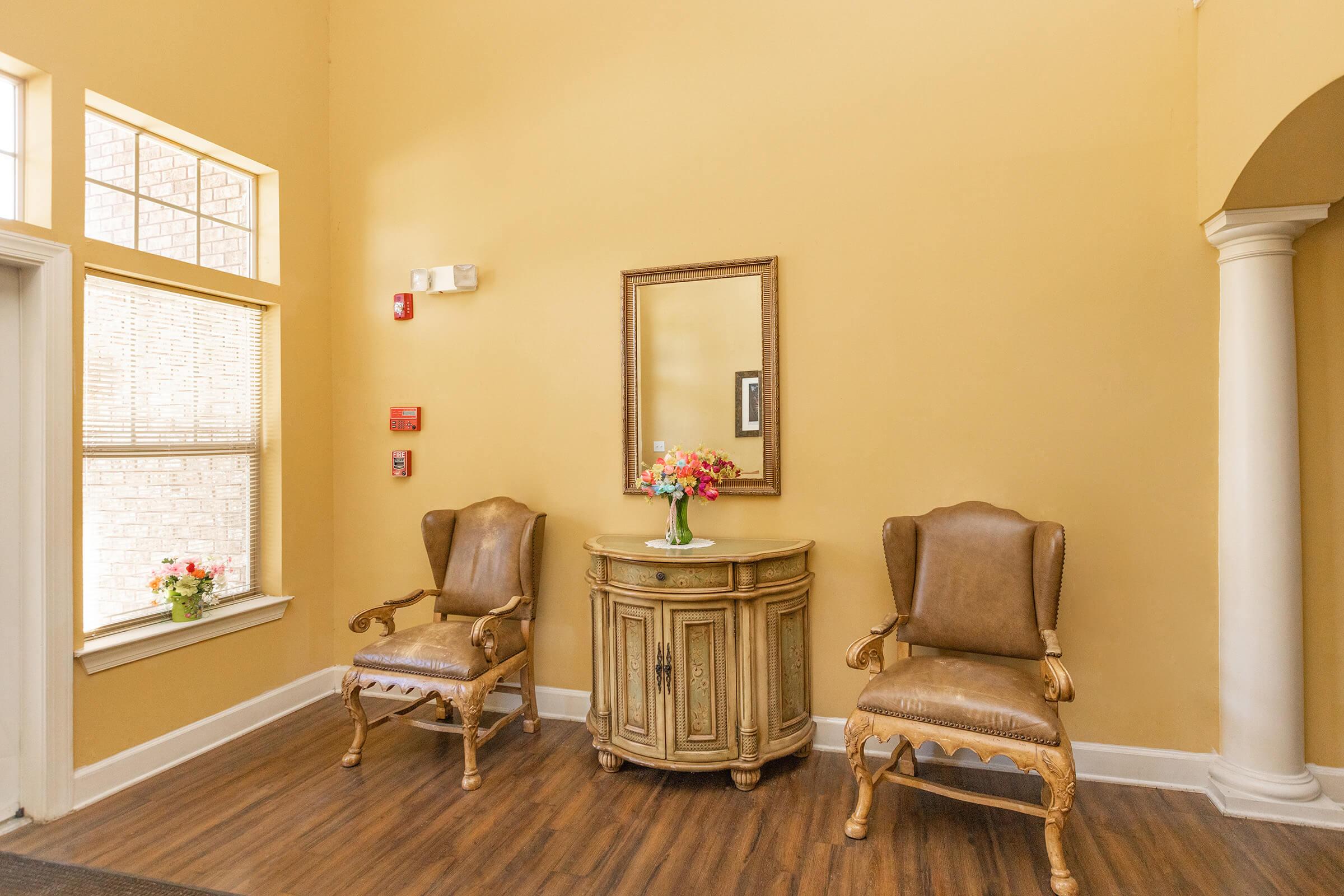 a bedroom with a bed and a chair in a room