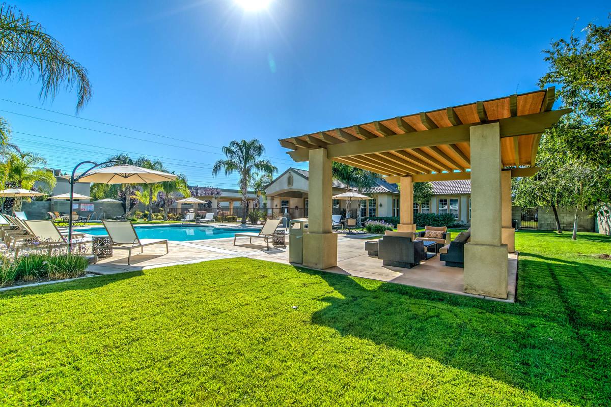 The community pool with a pergola and green grass