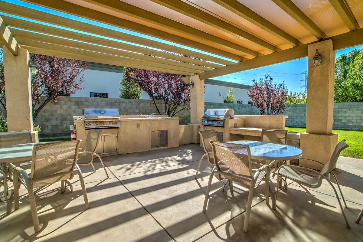 Tables and chairs next to a stainless steel barbecue