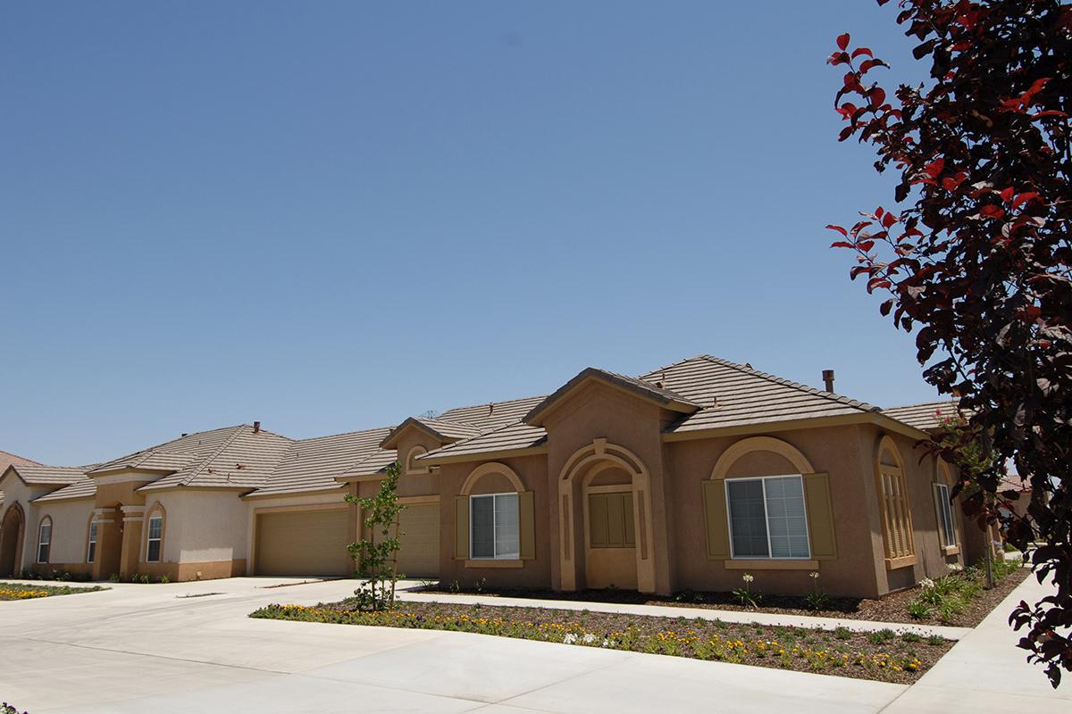 Community building with green trees and garages