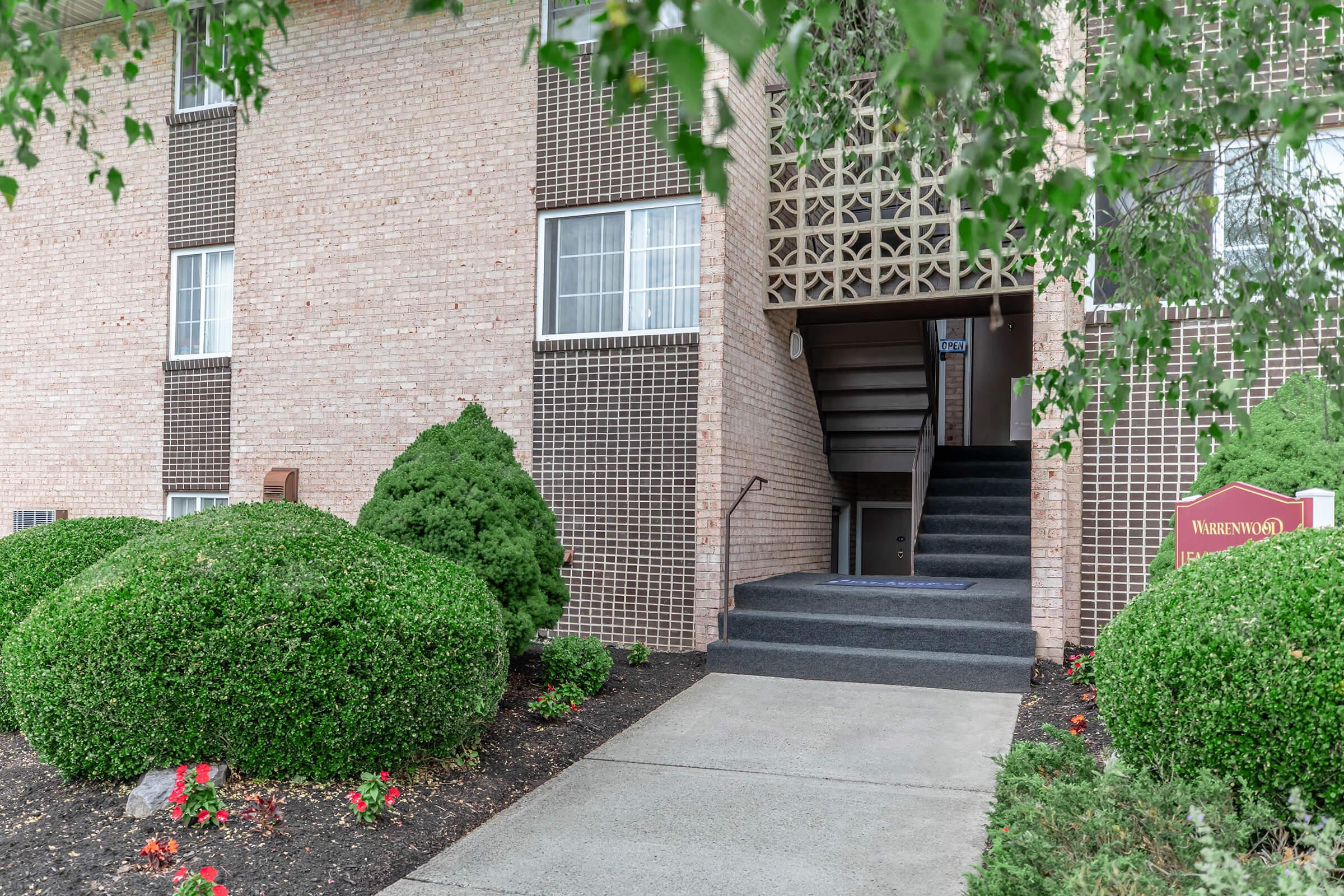 a garden in front of a brick building