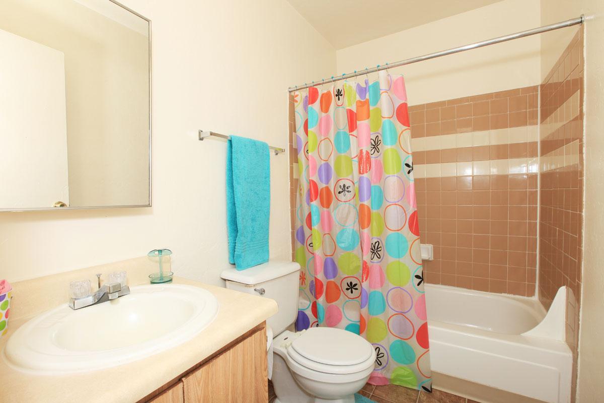a white sink sitting next to a shower curtain