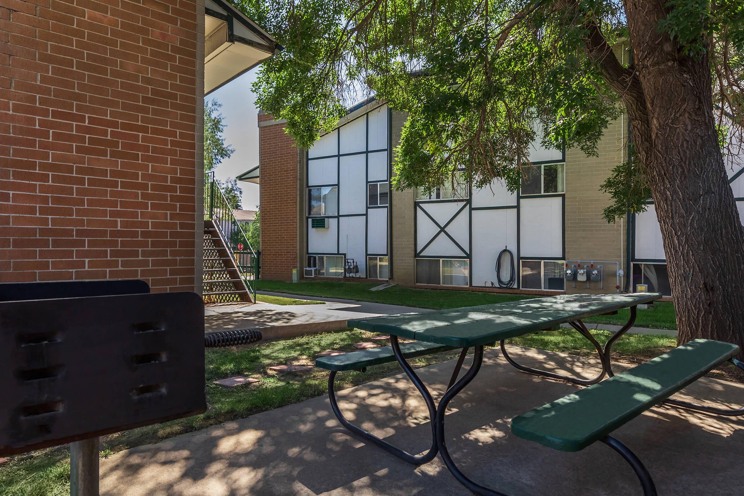 an empty park bench next to a brick wall