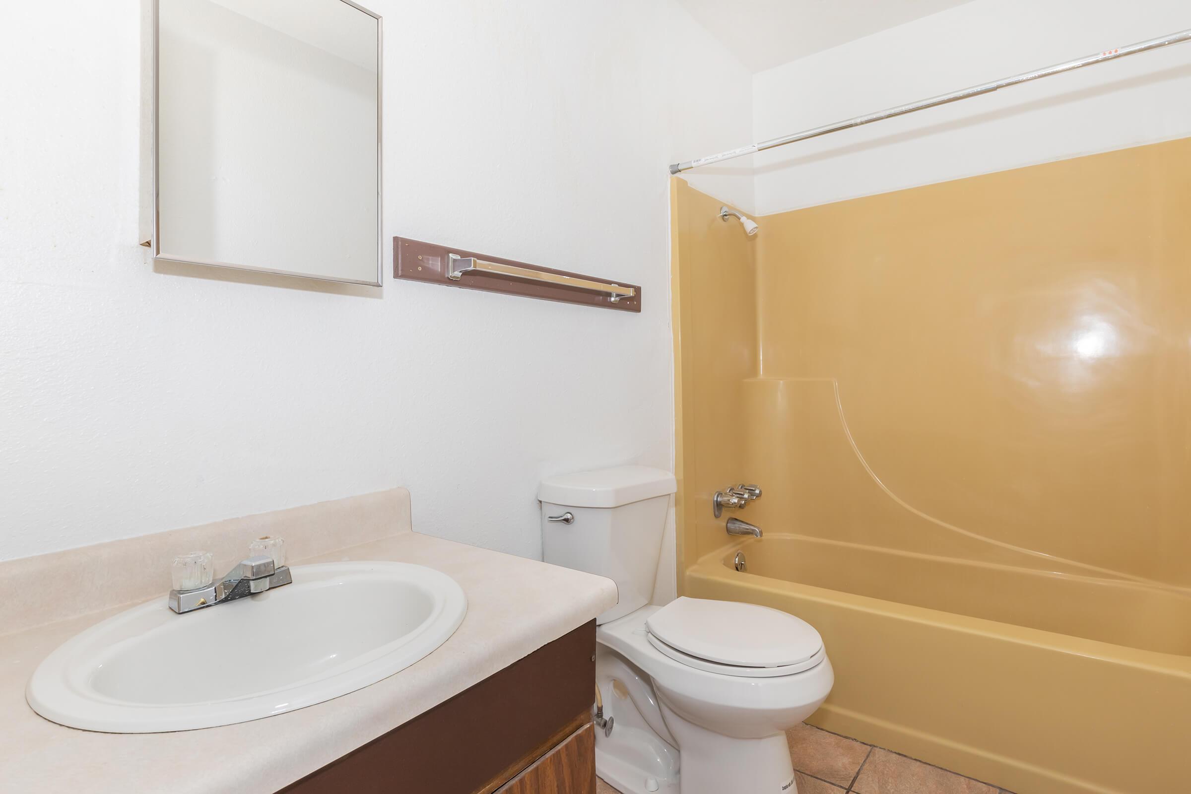 a white sink sitting under a mirror