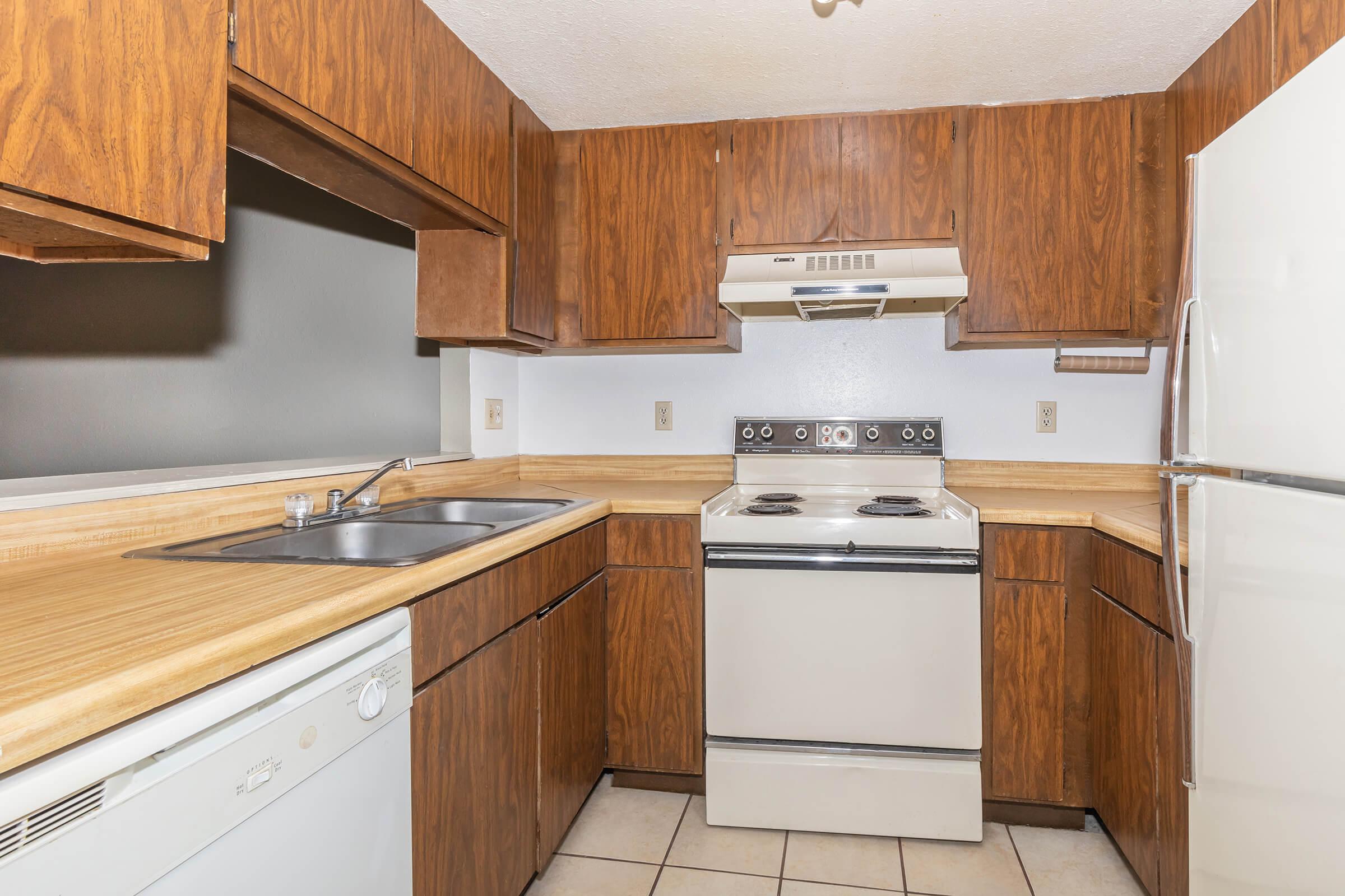 a kitchen with white appliances and wooden cabinets