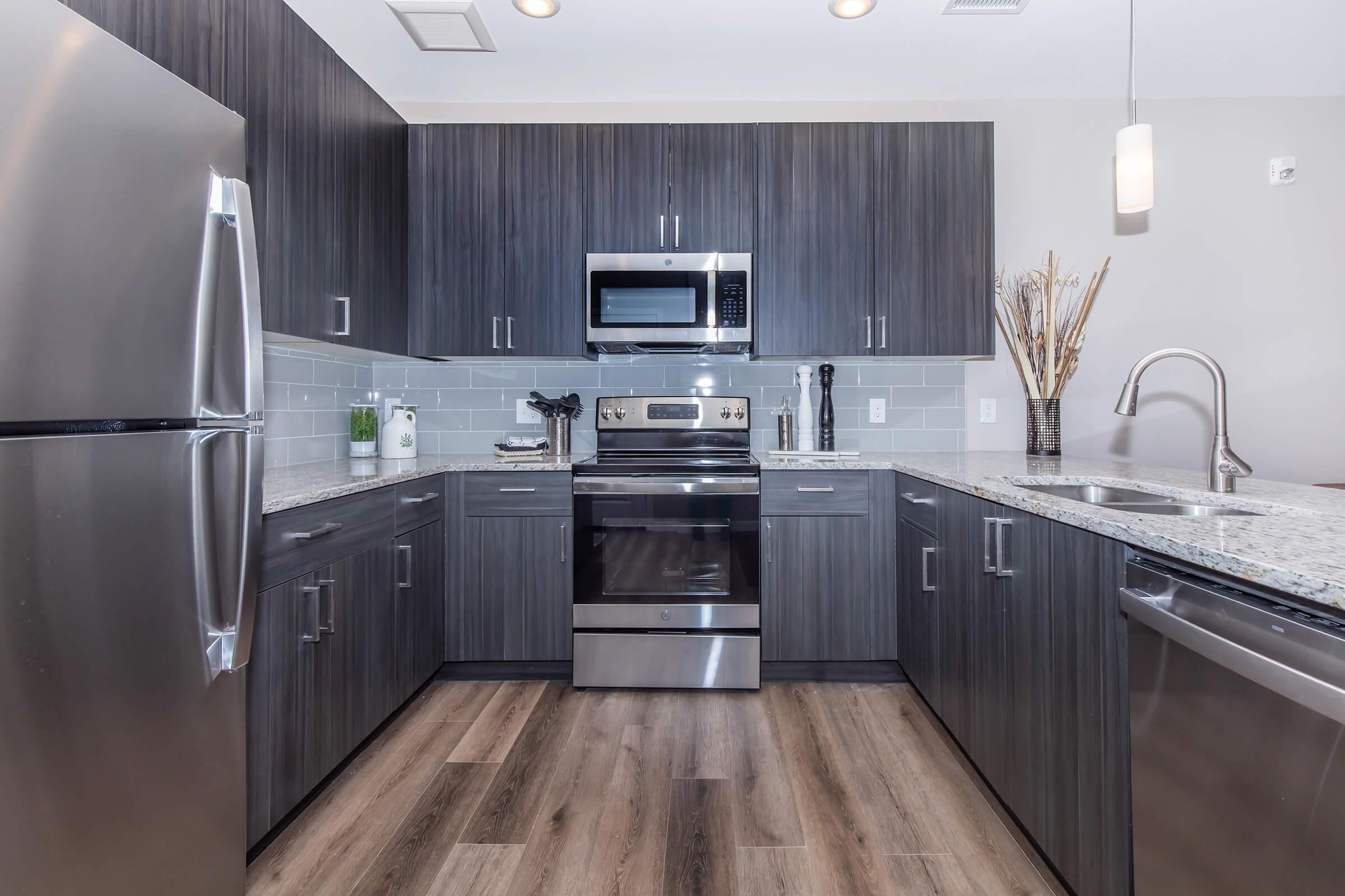 a modern kitchen with stainless steel appliances and wooden cabinets