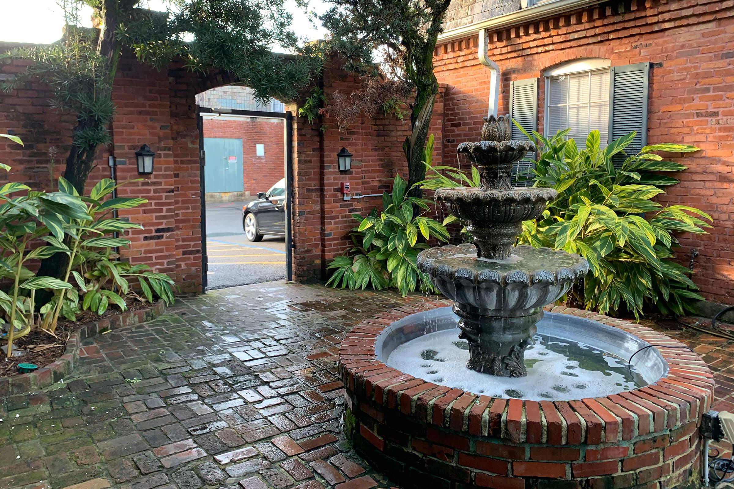 a large stone statue in front of a brick building
