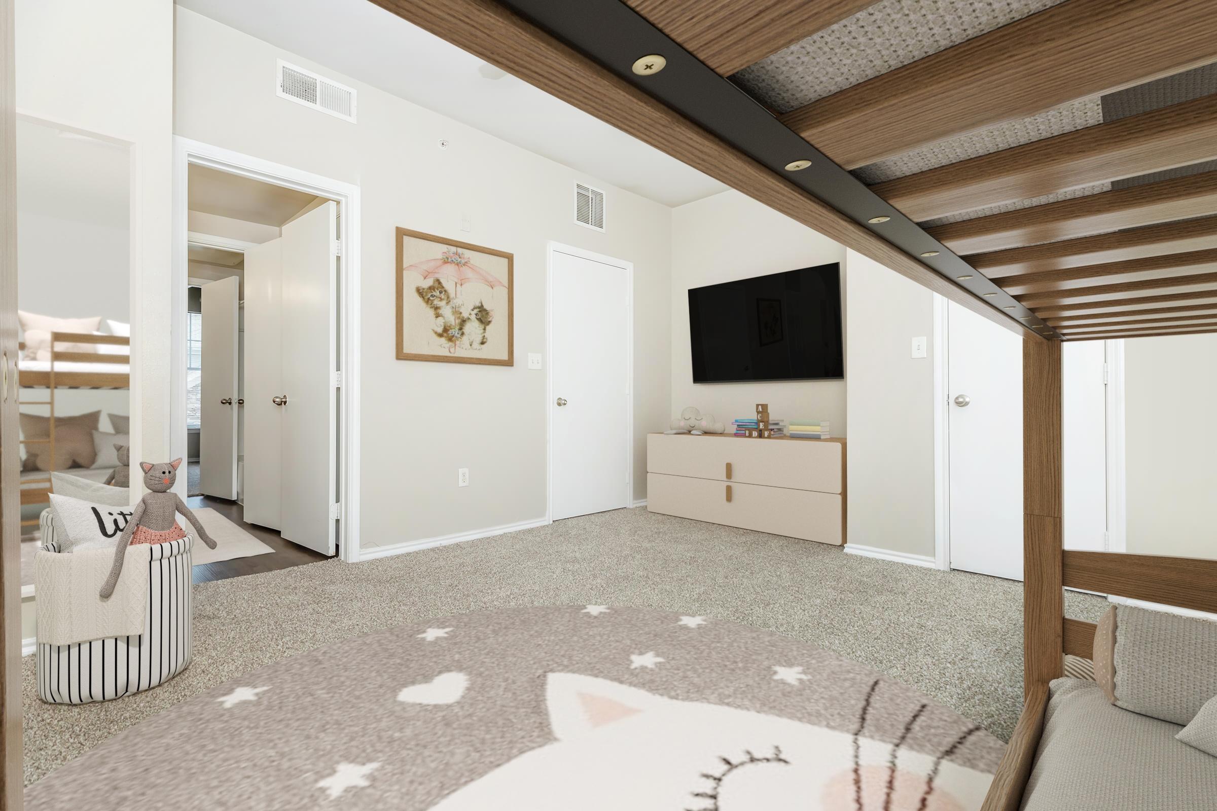 A cozy room featuring a wooden bed frame, light-colored walls, and plush carpet. There's a television mounted on the wall and a stylish dresser beneath it. A cute cat-themed rug is on the floor, and a small basket holds a plush toy cat. Two doors lead to adjacent rooms, adding to the inviting atmosphere.