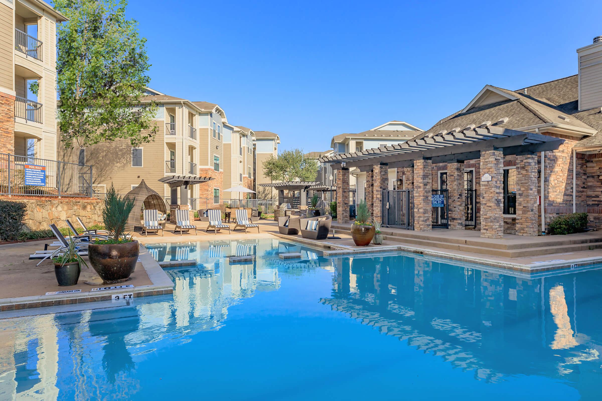 a large brick building with a pool of water