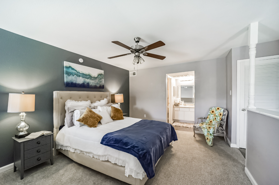 a bedroom with a bed and desk in a room