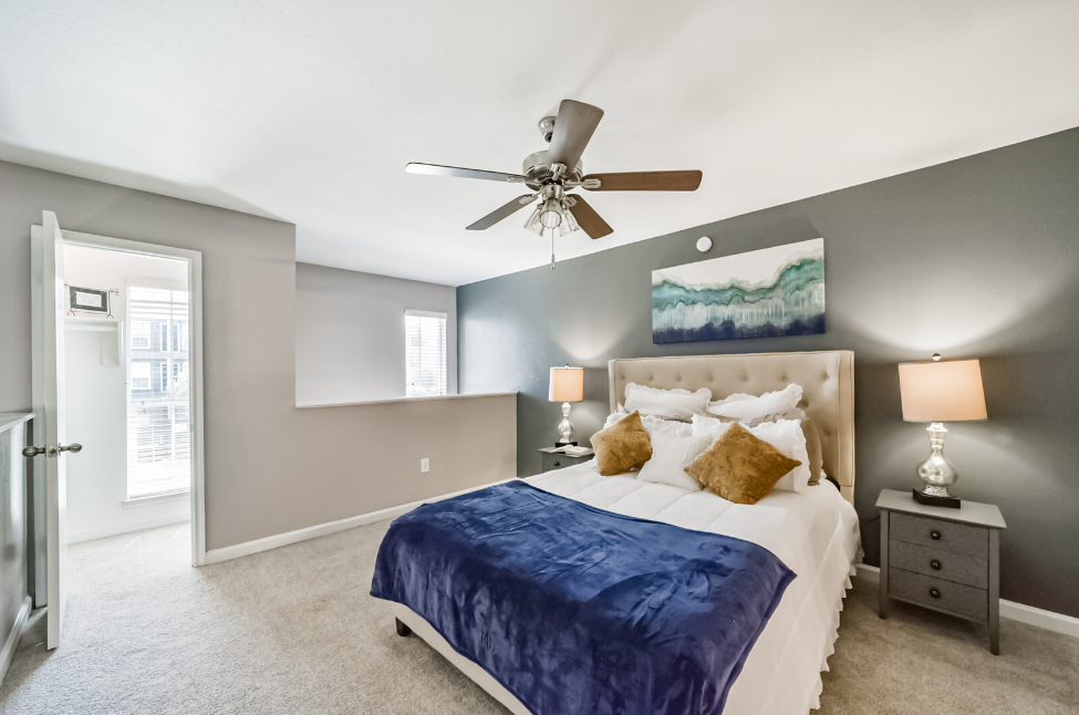 a bedroom with a bed and desk in a room