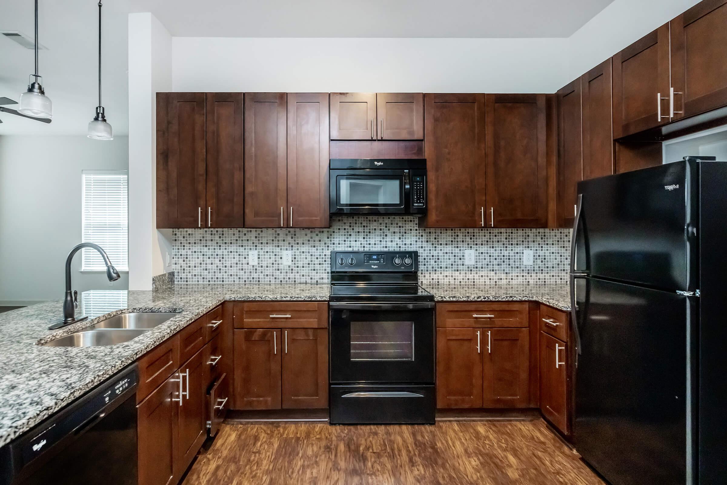 a modern kitchen with stainless steel appliances and wooden cabinets