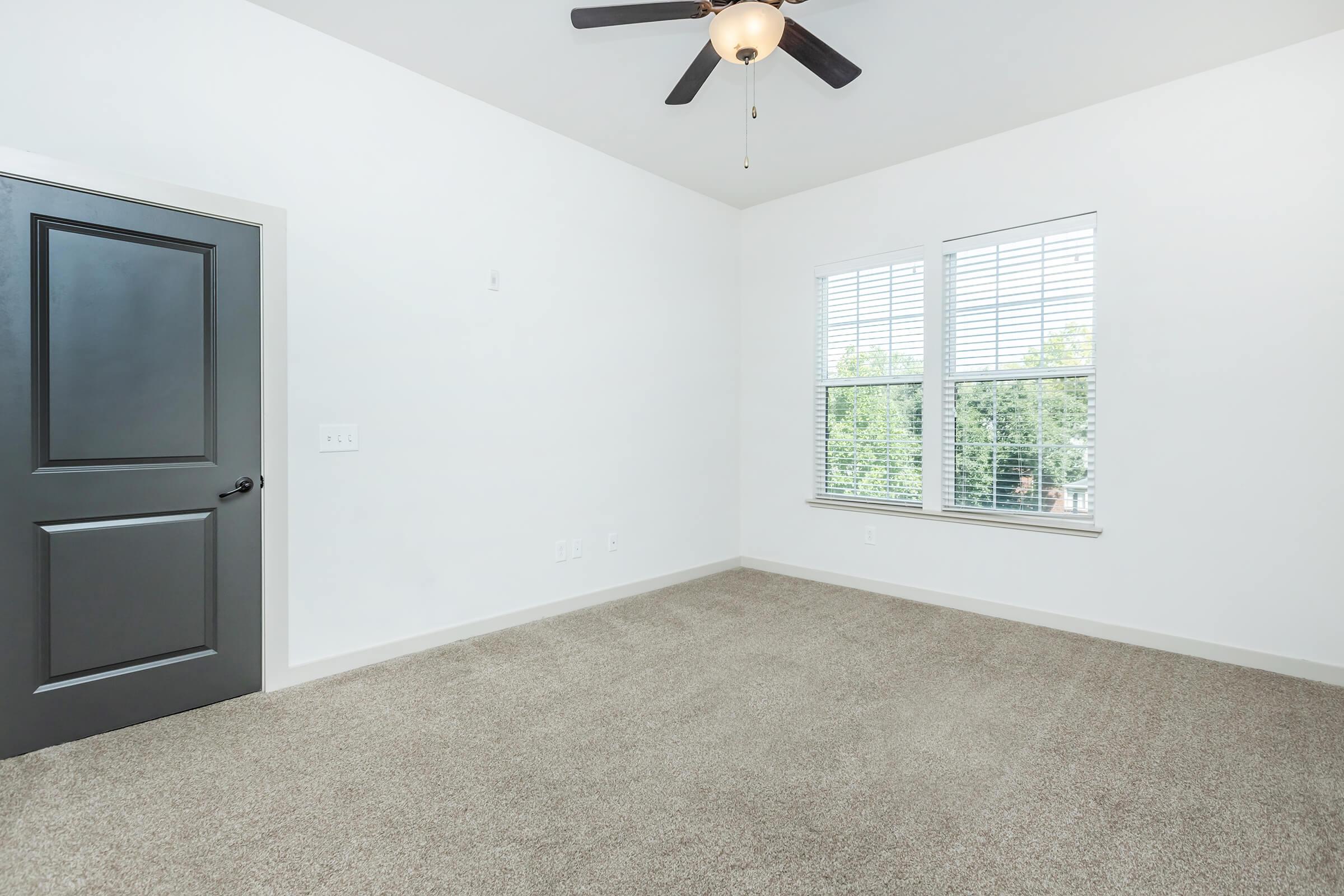 Bedroom 1 with entrance door and carpeted flooring