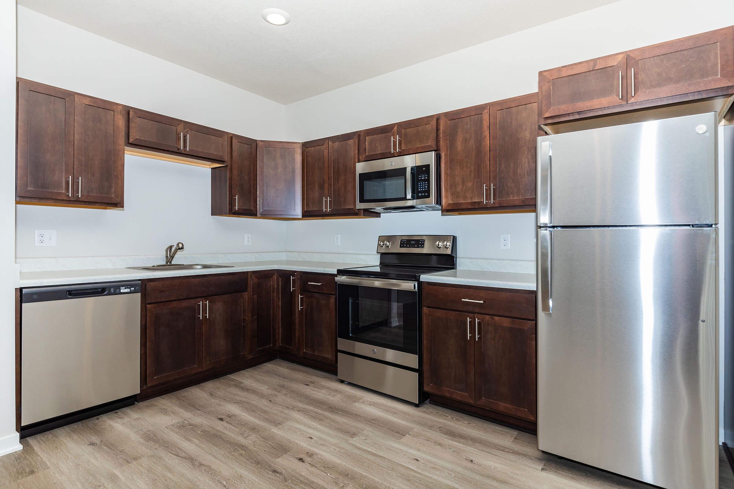 a kitchen with stainless steel appliances and wooden cabinets