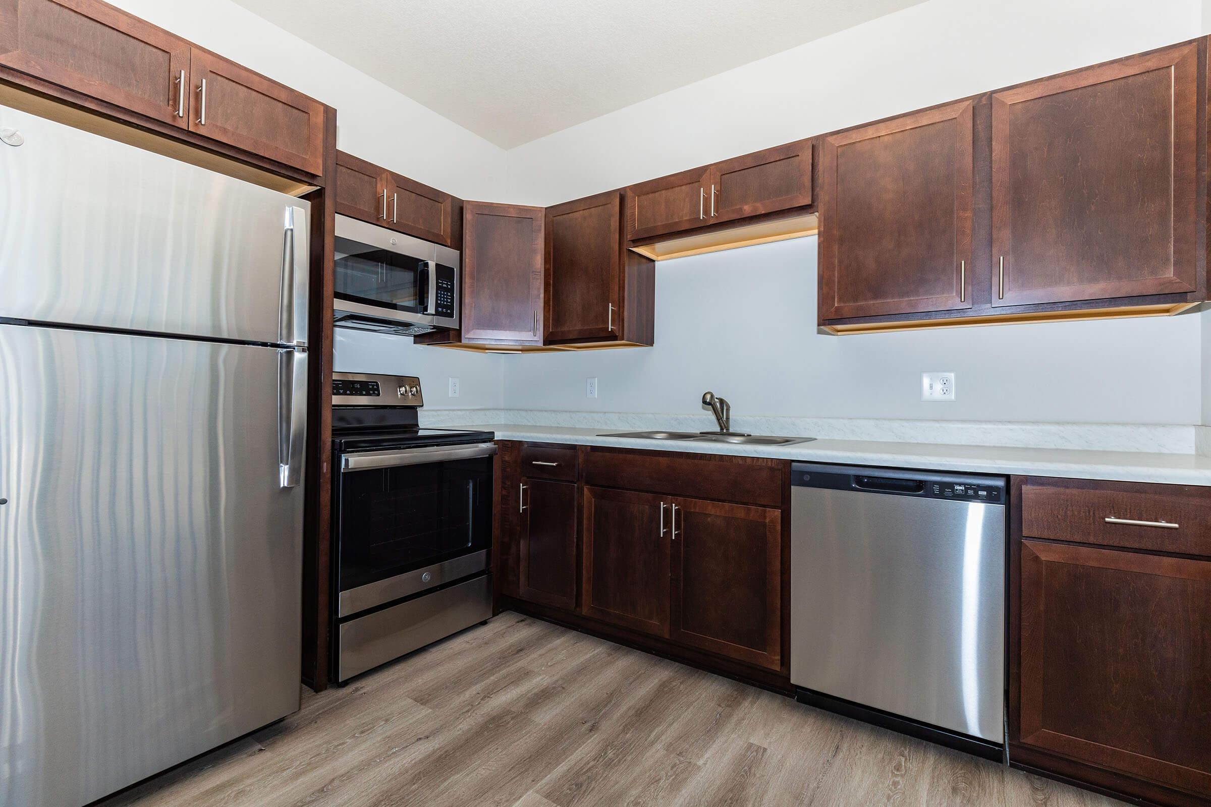 a kitchen with stainless steel appliances and wooden cabinets