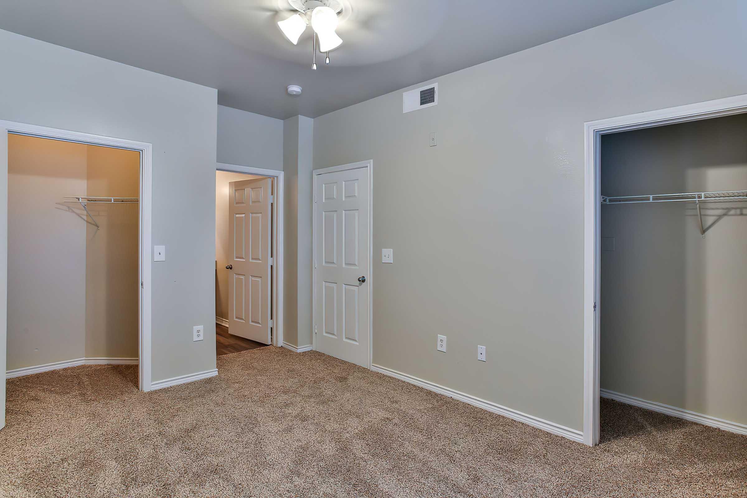 A well-lit room with beige carpeting and light gray walls.