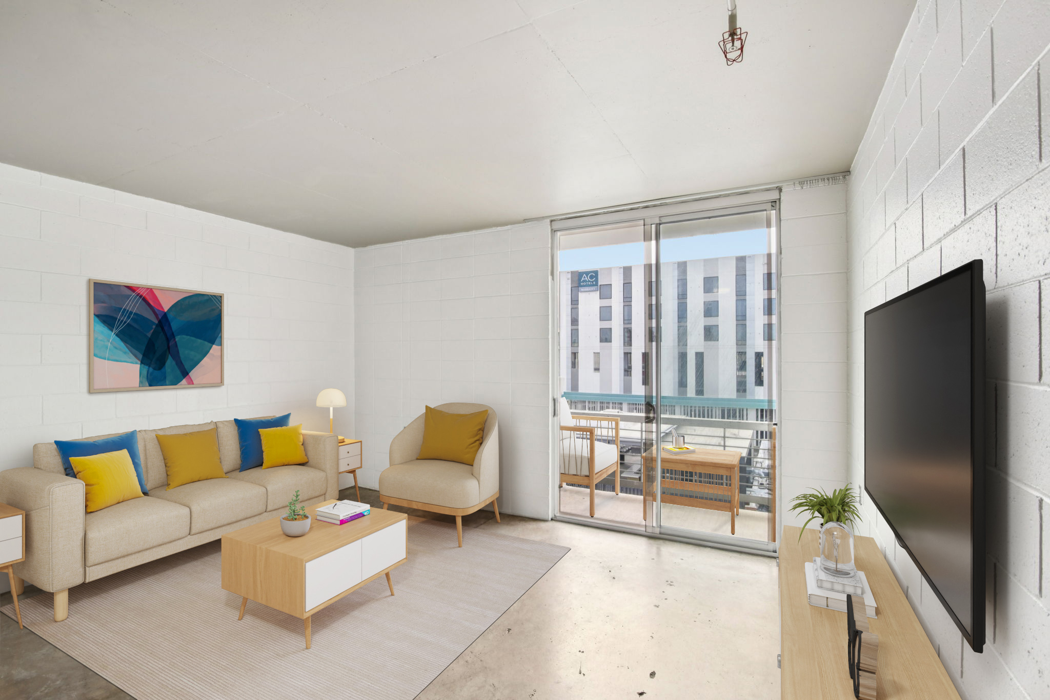 A modern living room featuring a light-colored sofa with yellow and blue pillows, an armchair, a coffee table, and a TV stand. The walls are white, and large windows let in natural light, revealing a balcony and an urban view. A soft rug adds warmth to the space.
