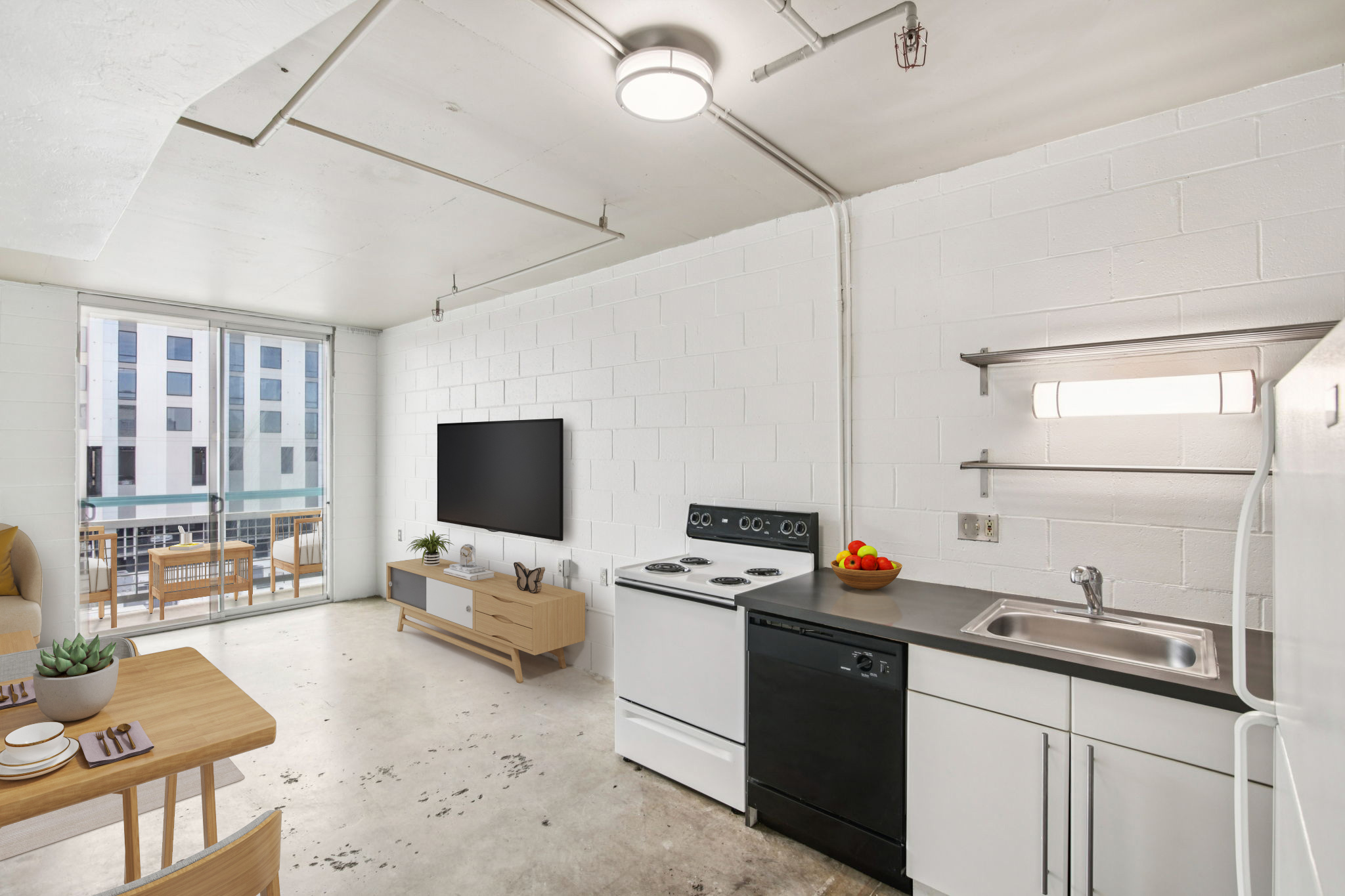 A modern, minimalistic apartment interior featuring a kitchenette with a stove, sink, and refrigerator, a dining area with a wooden table and chairs, a living space with a wall-mounted TV, and large windows providing natural light. The decor is simple and stylish with a few decorative items.