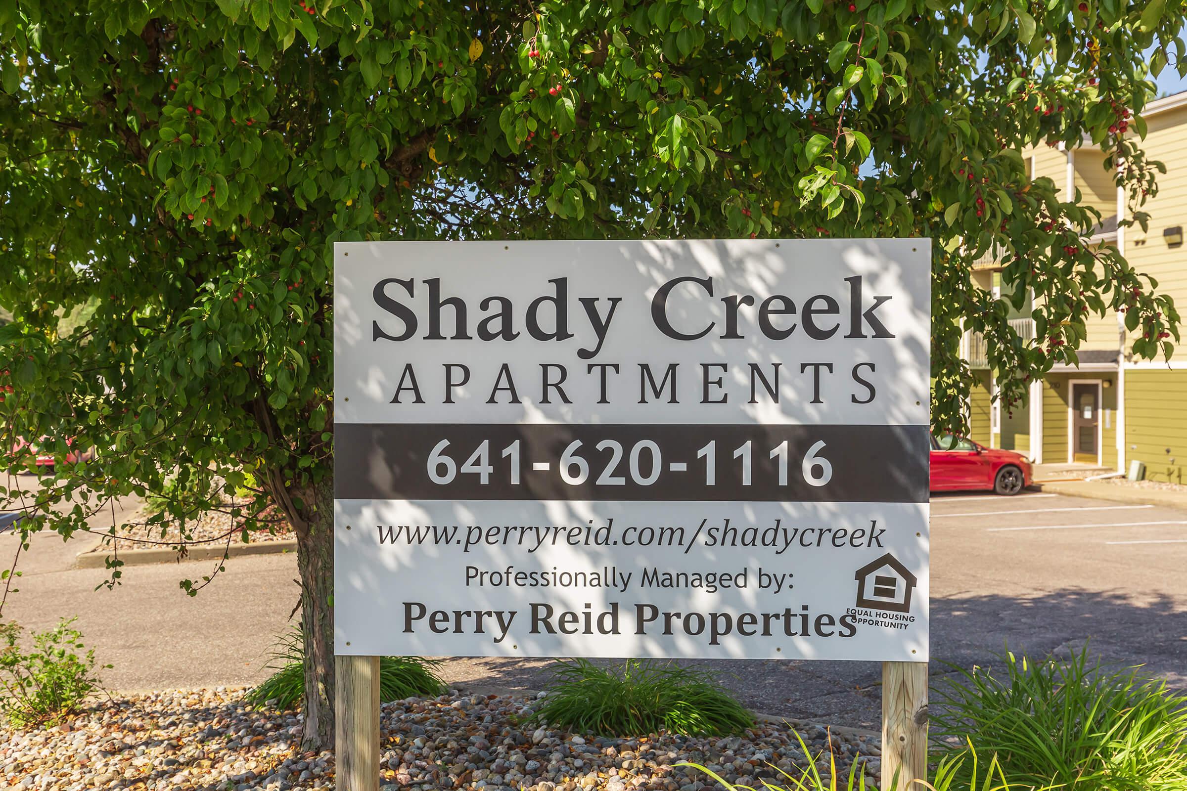 a sign in front of a tree