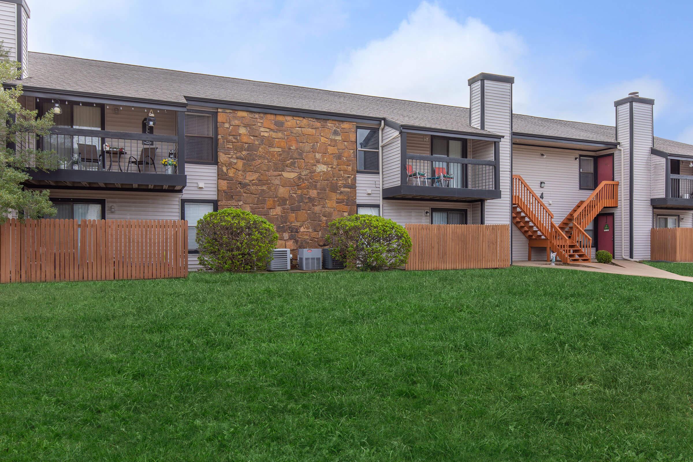 a large brick building with grass in front of a house