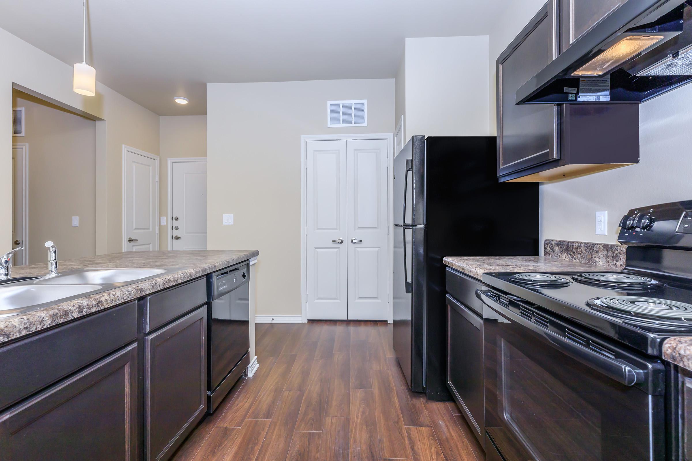 a modern kitchen with stainless steel appliances and wooden cabinets