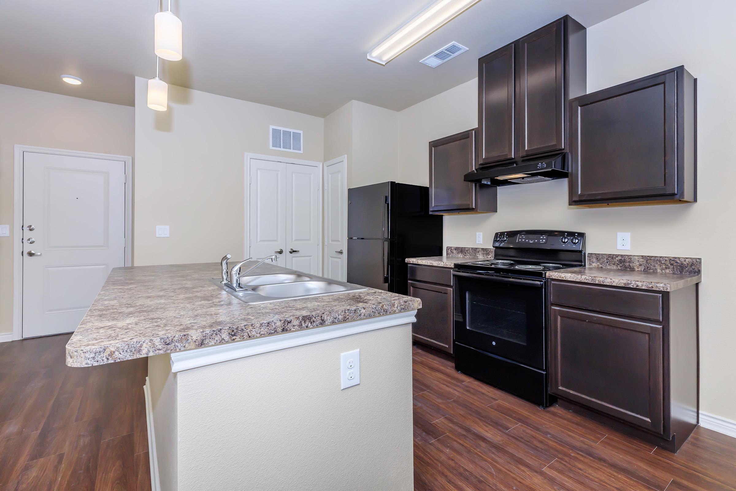 a modern kitchen with stainless steel appliances and wooden cabinets