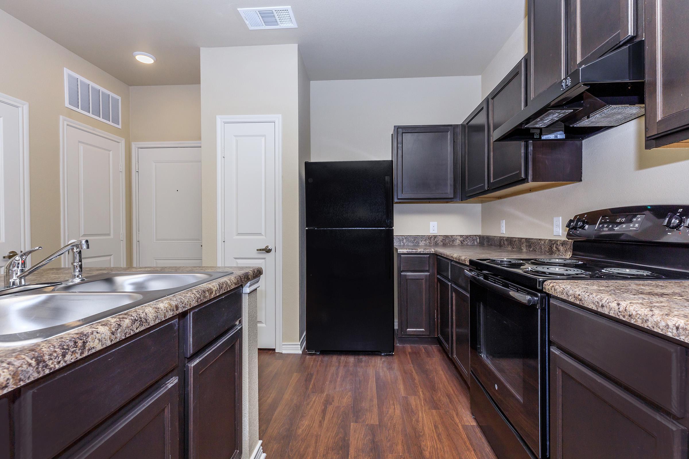 a modern kitchen with stainless steel appliances and wooden cabinets