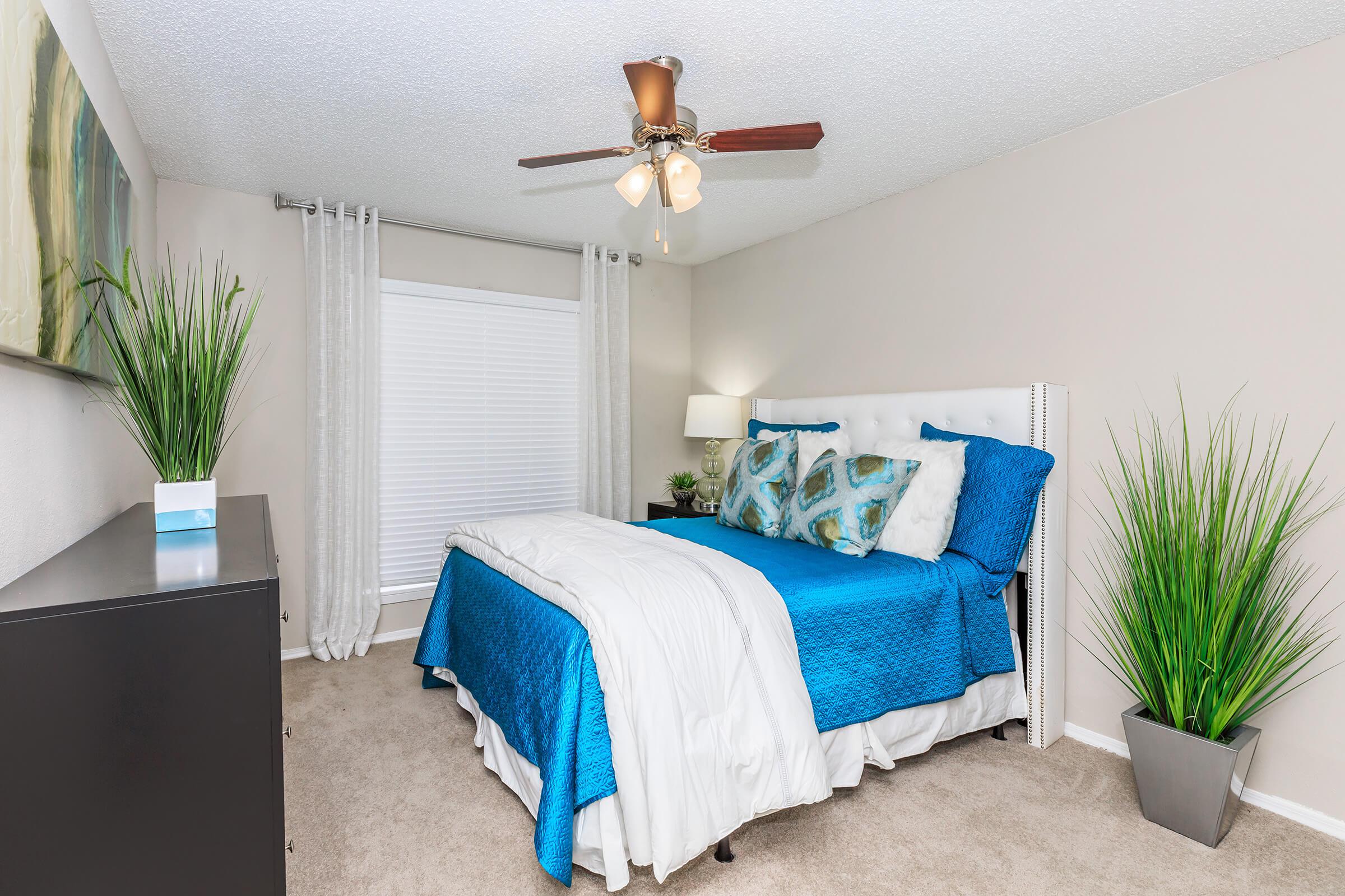 a living room filled with furniture and vase of flowers sits on a bed