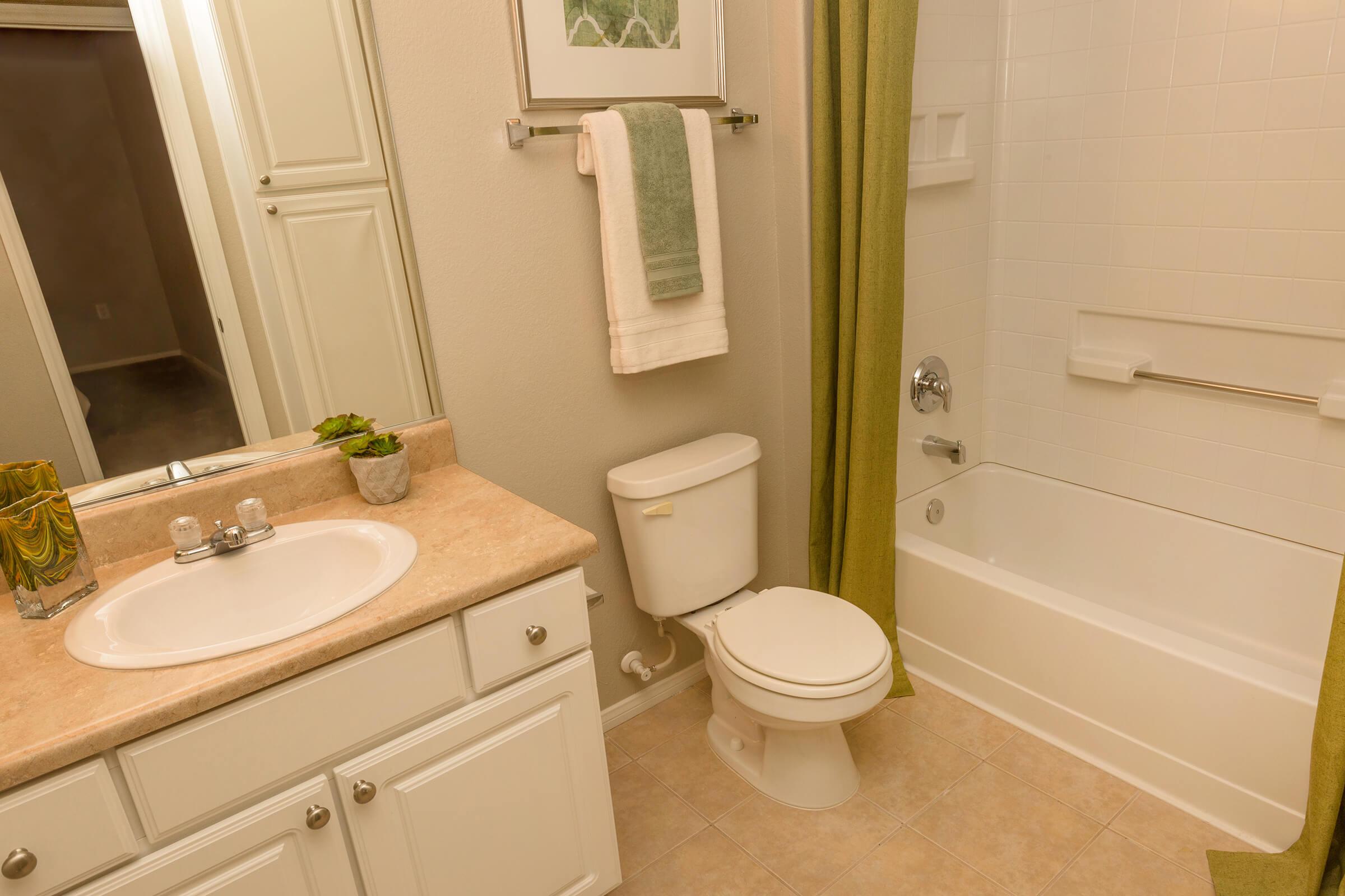 a white sink sitting under a mirror