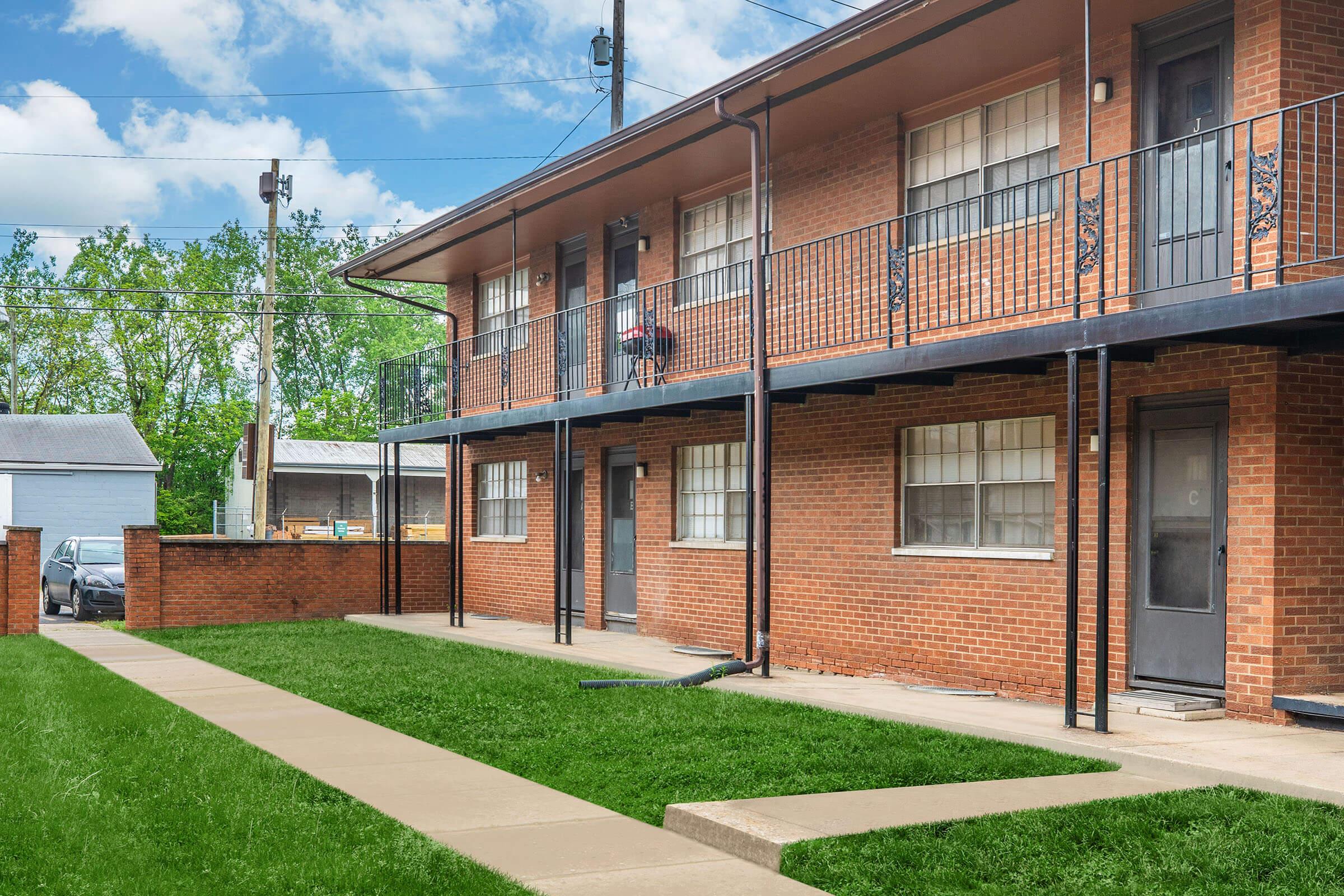 a large lawn in front of a brick building