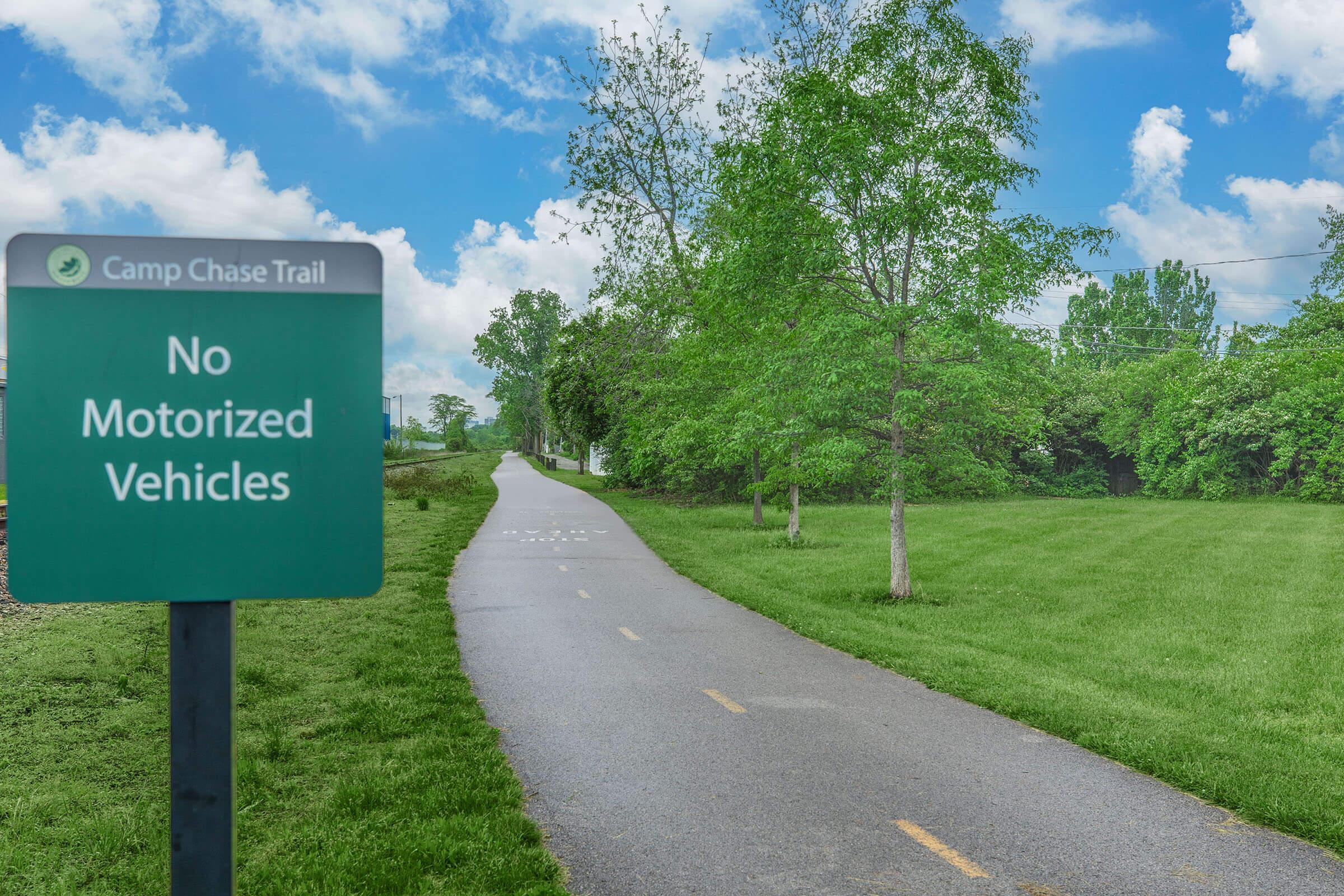 a sign on the side of a lush green field