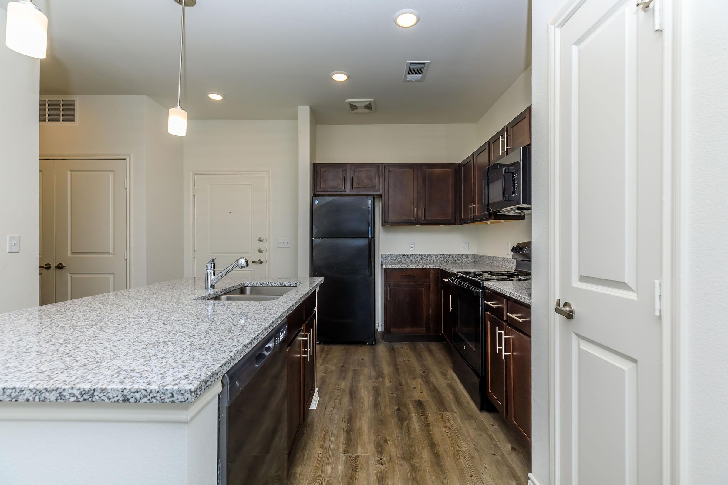 a large kitchen with stainless steel appliances and wooden cabinets