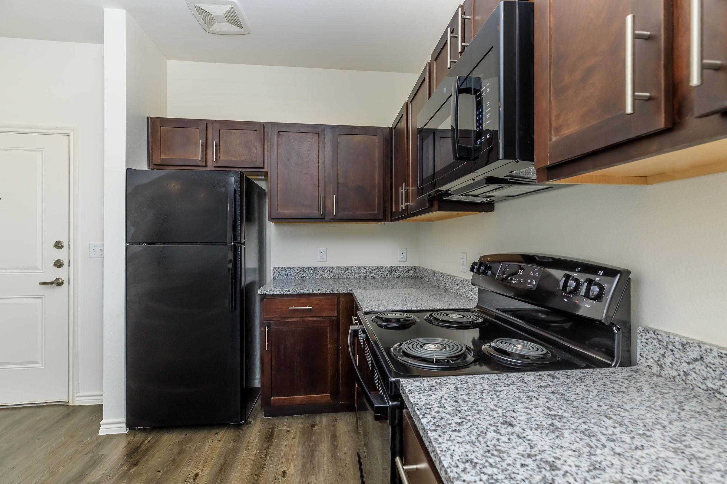 a large kitchen with stainless steel appliances and wooden cabinets