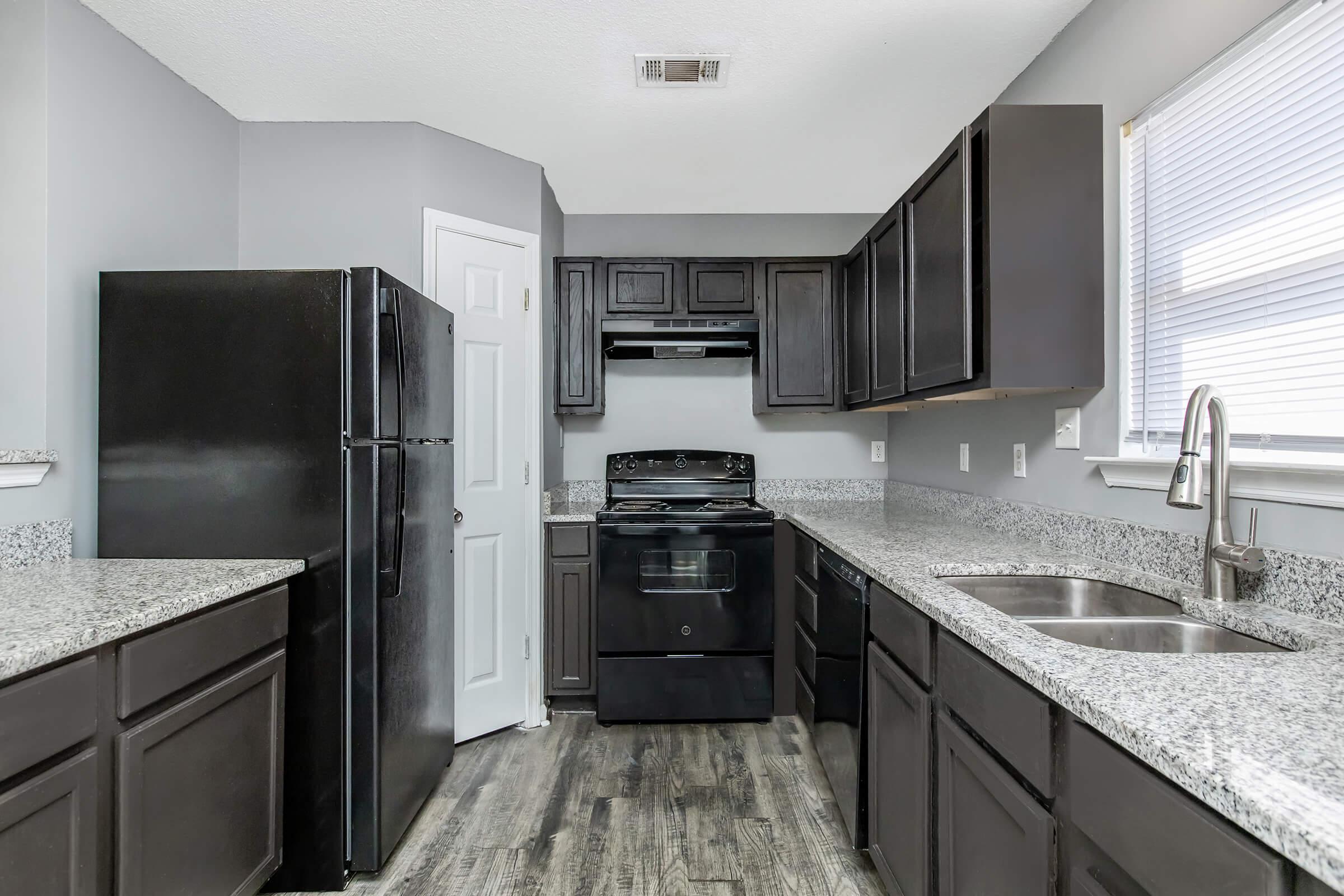 a large kitchen with stainless steel appliances and wooden cabinets