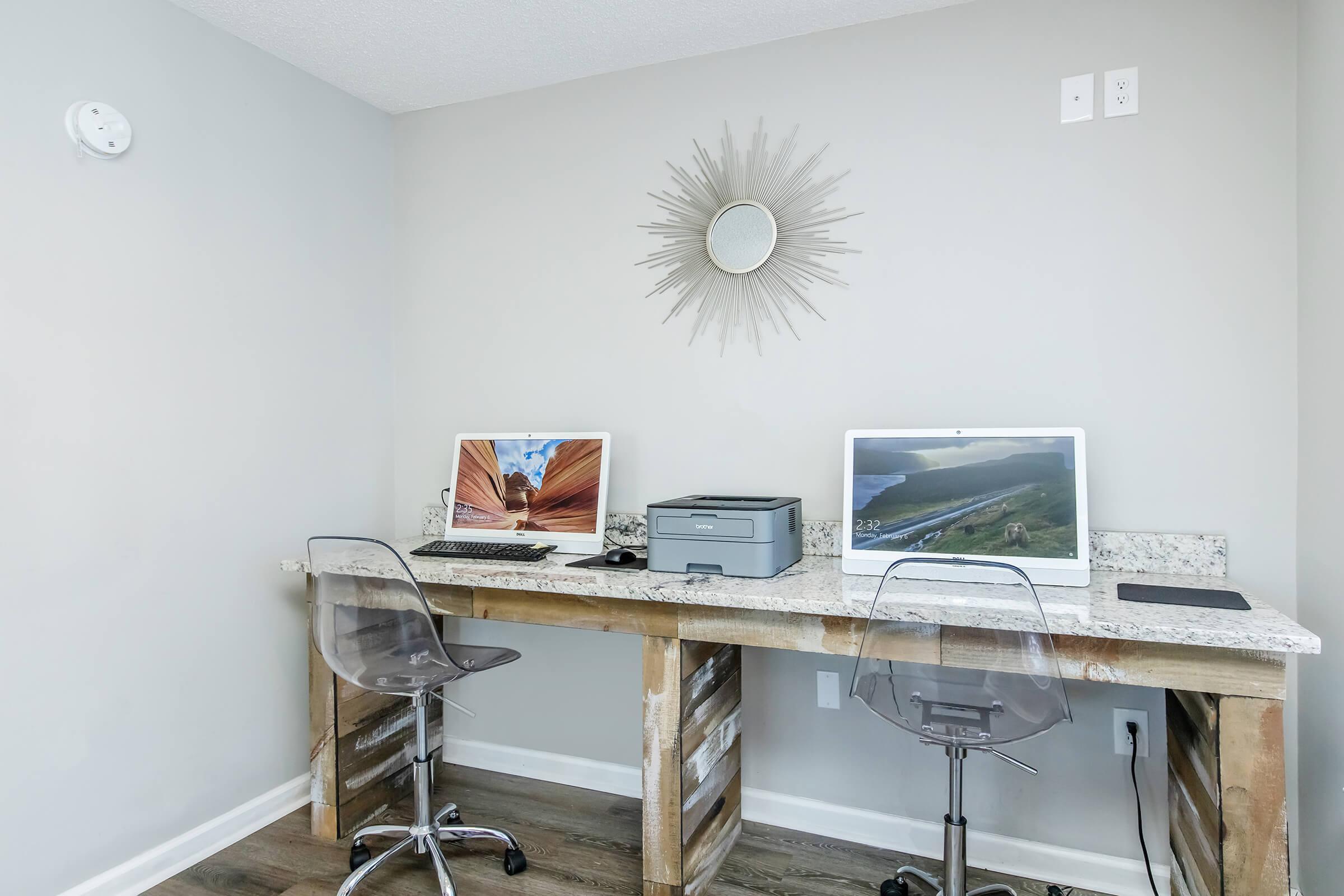 a desk with a computer and a chair in a room