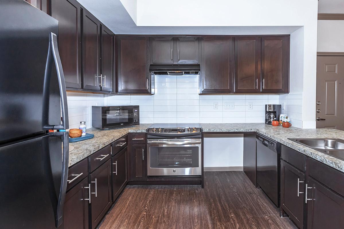 a modern kitchen with stainless steel appliances and wooden cabinets