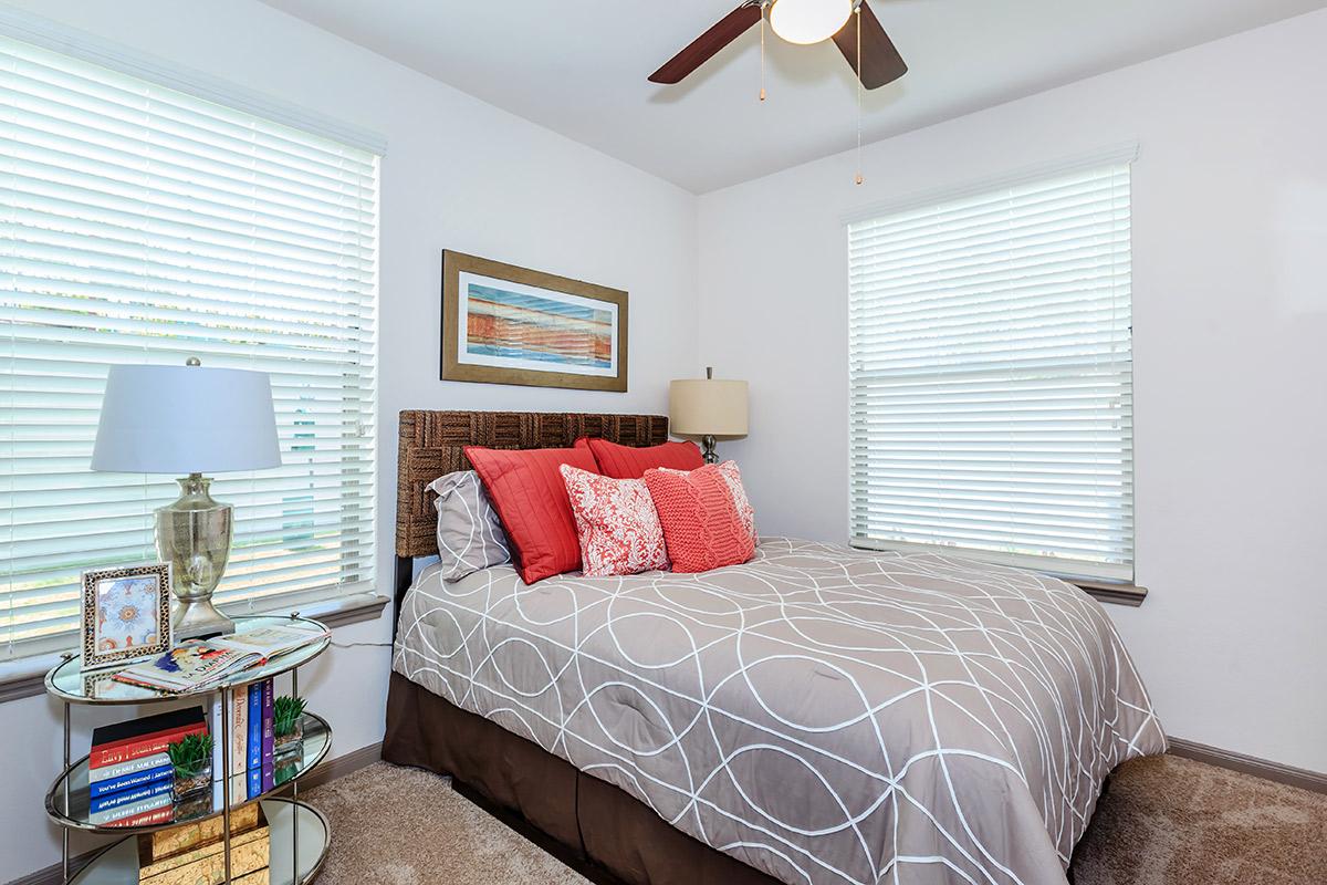 a bedroom with a bed and a chair in a room