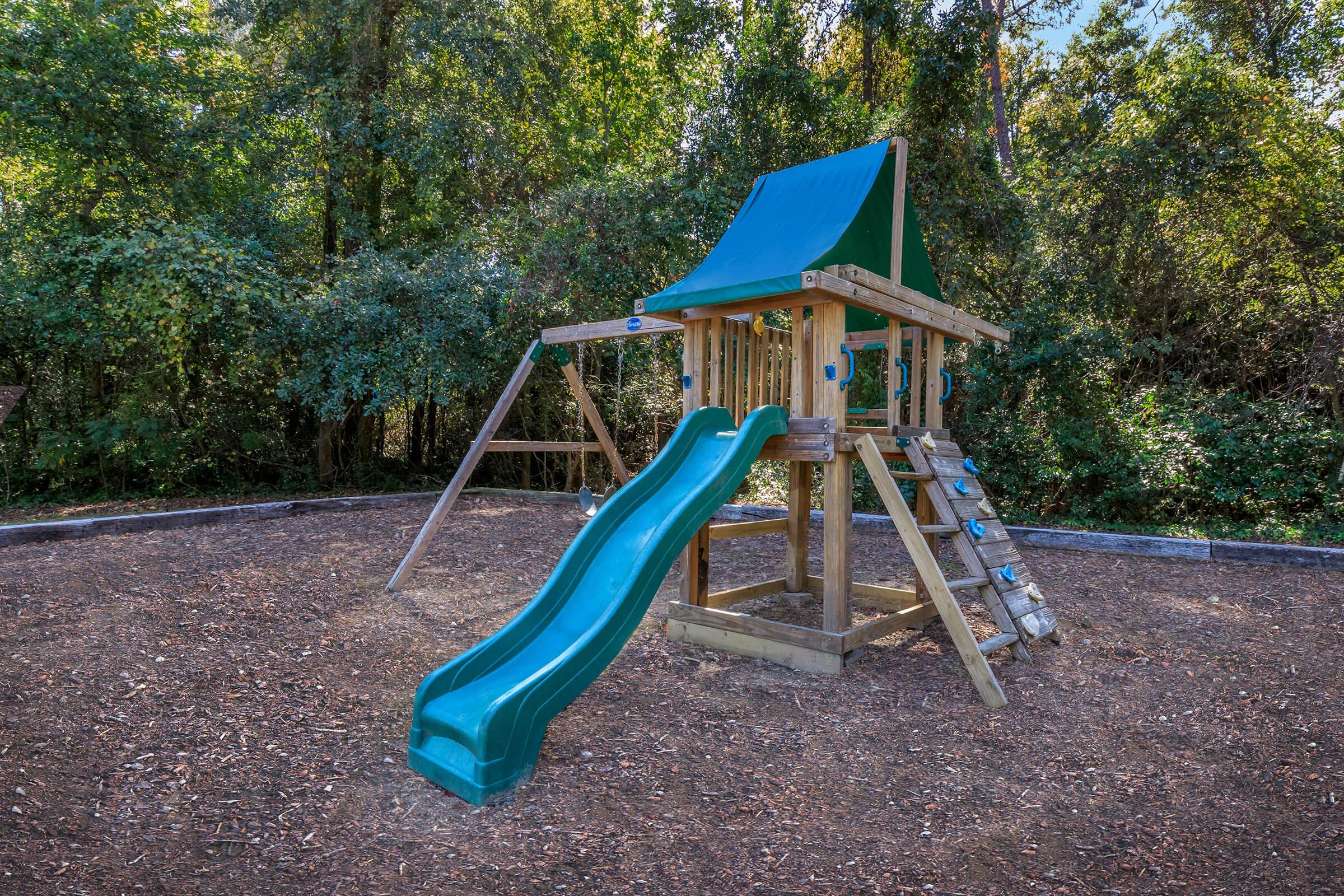 a playground in front of a blue bench