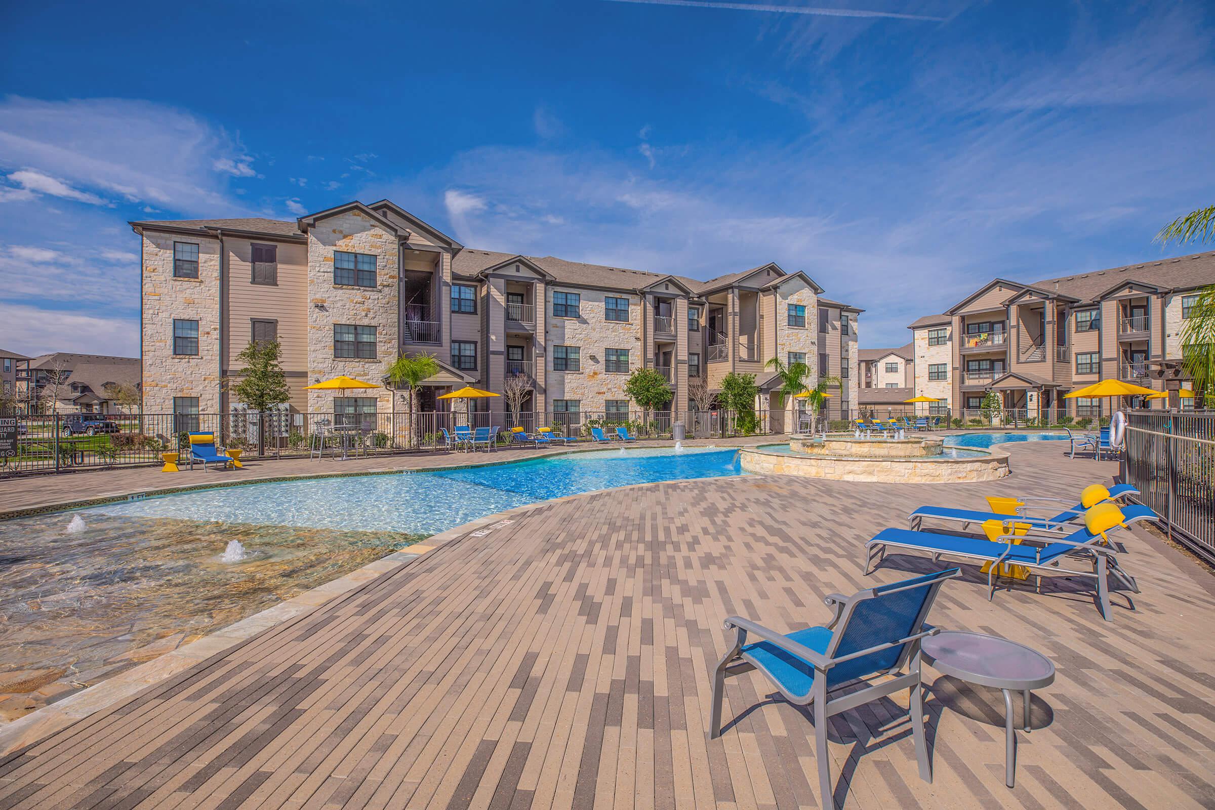 A LARGE TANNING DECK SURROUNDS THE POOL