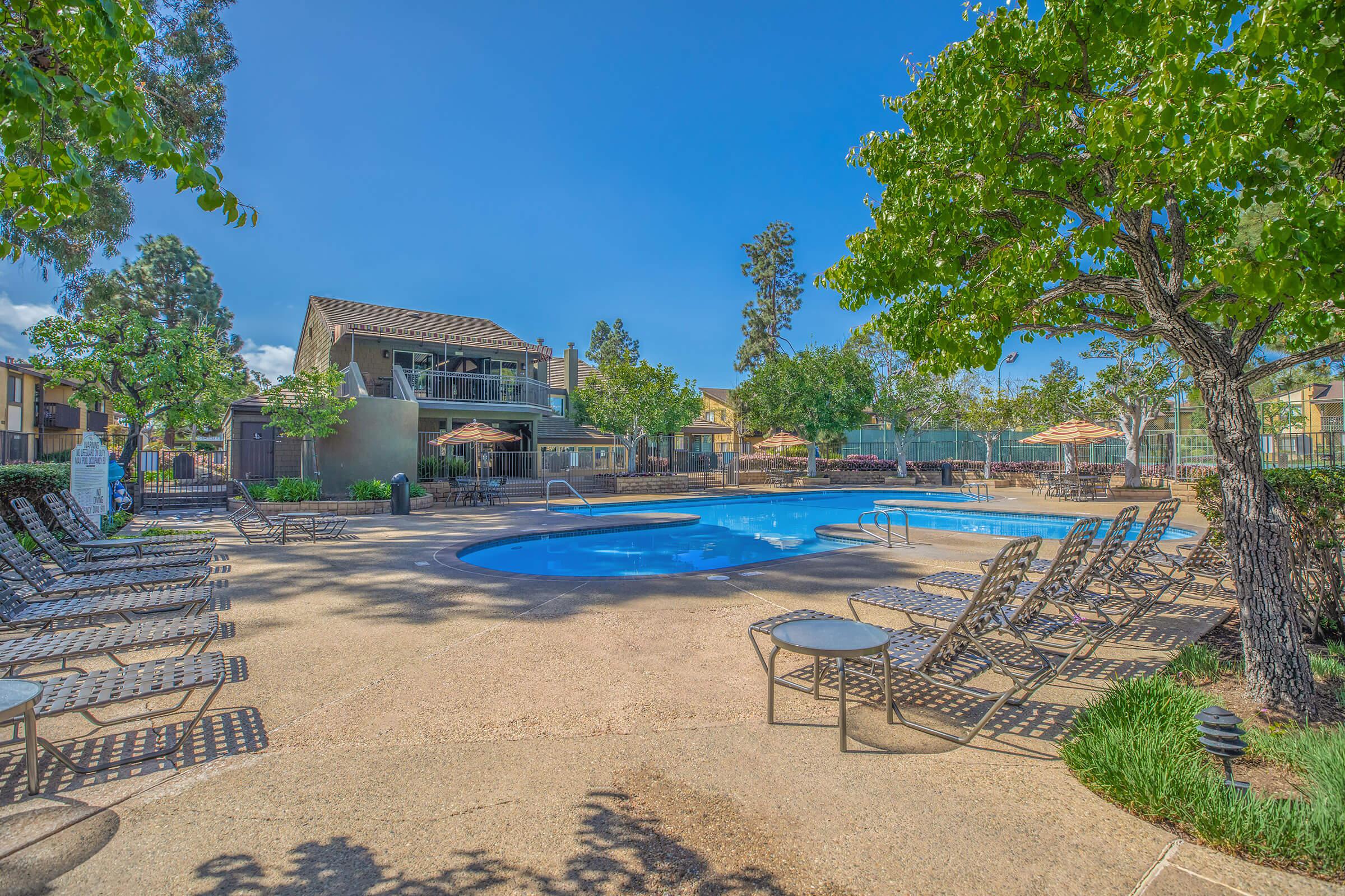 The community pool with green landscaping