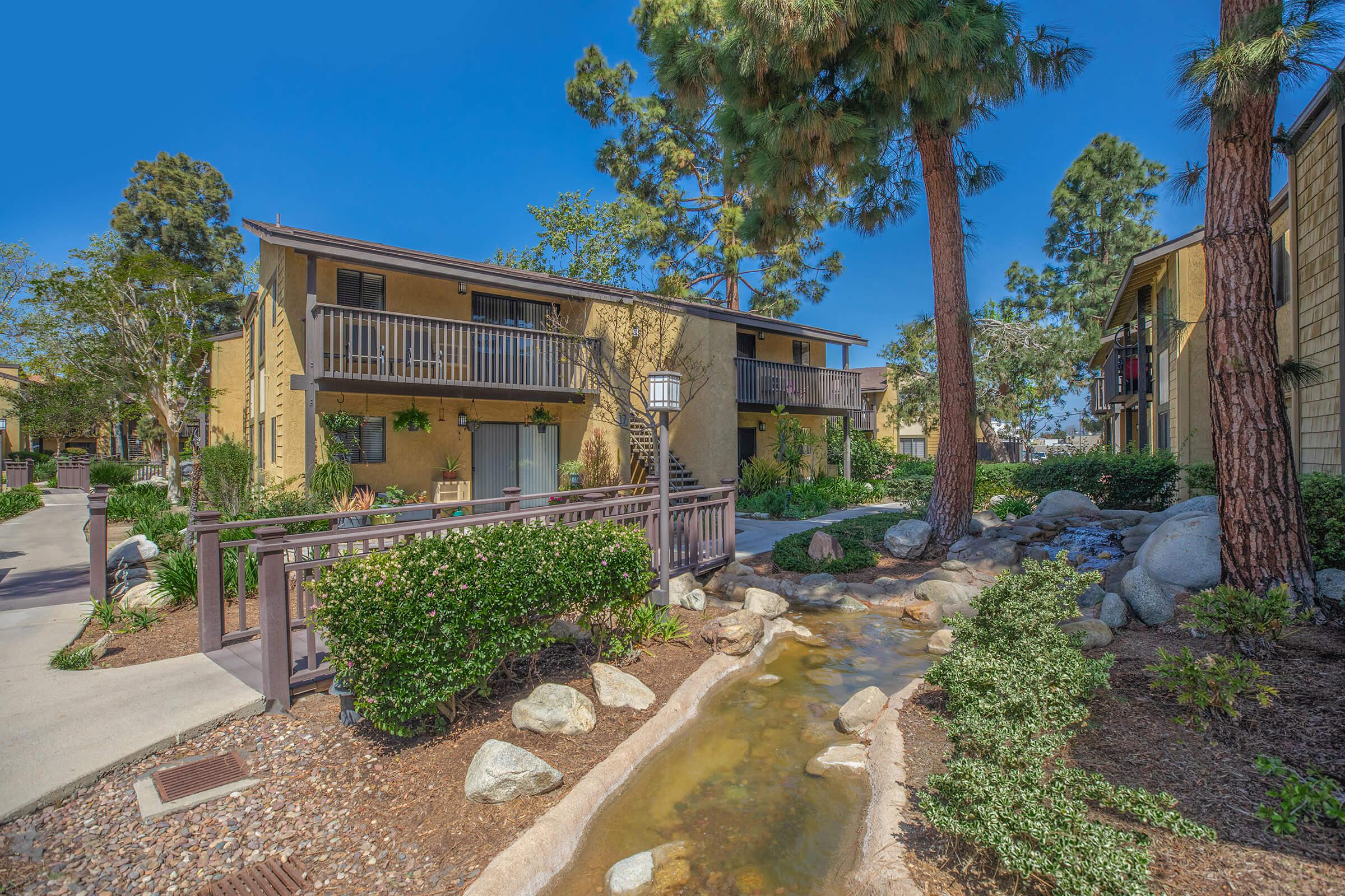 Pinecreek Village Apartments community buildings with green landscaping