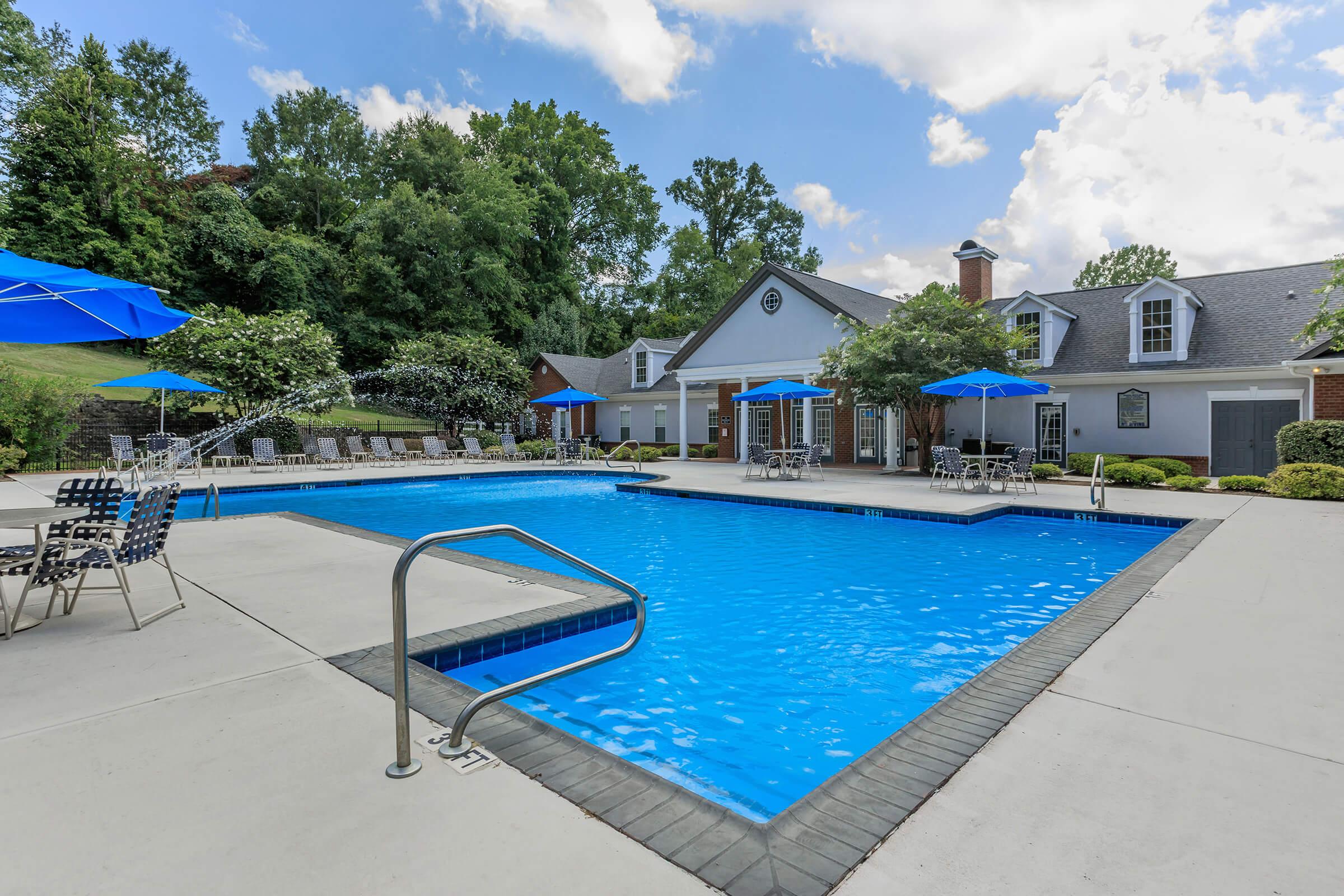 a group of lawn chairs sitting on top of a blue pool of water