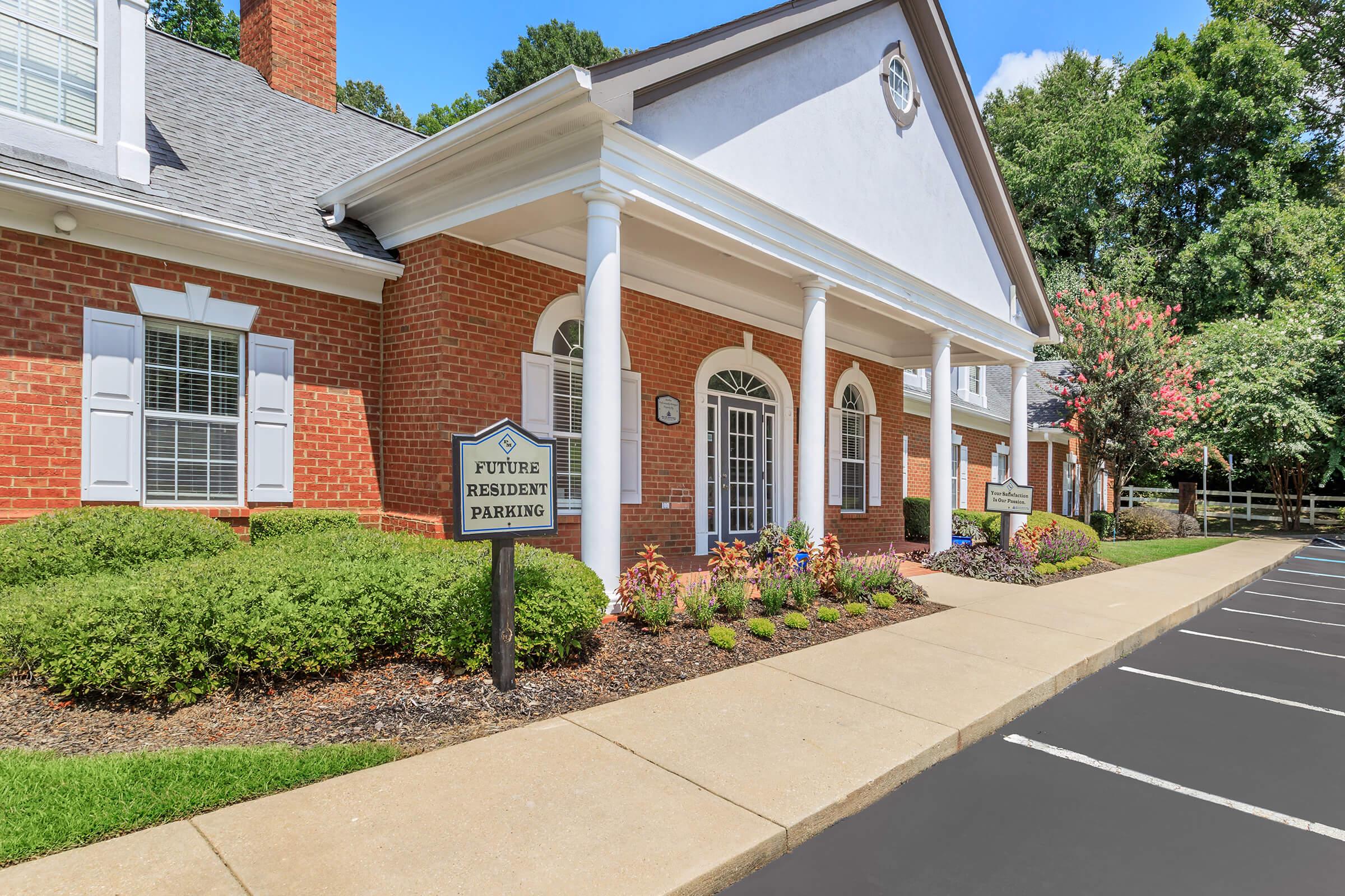 a large brick building with grass in front of a house