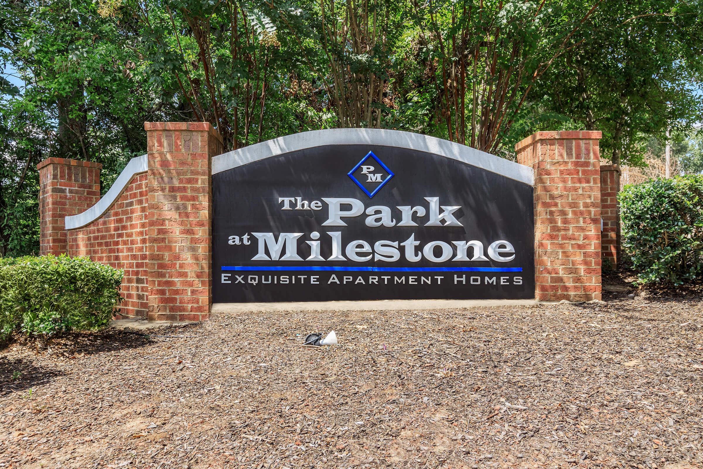 a sign in front of a brick wall