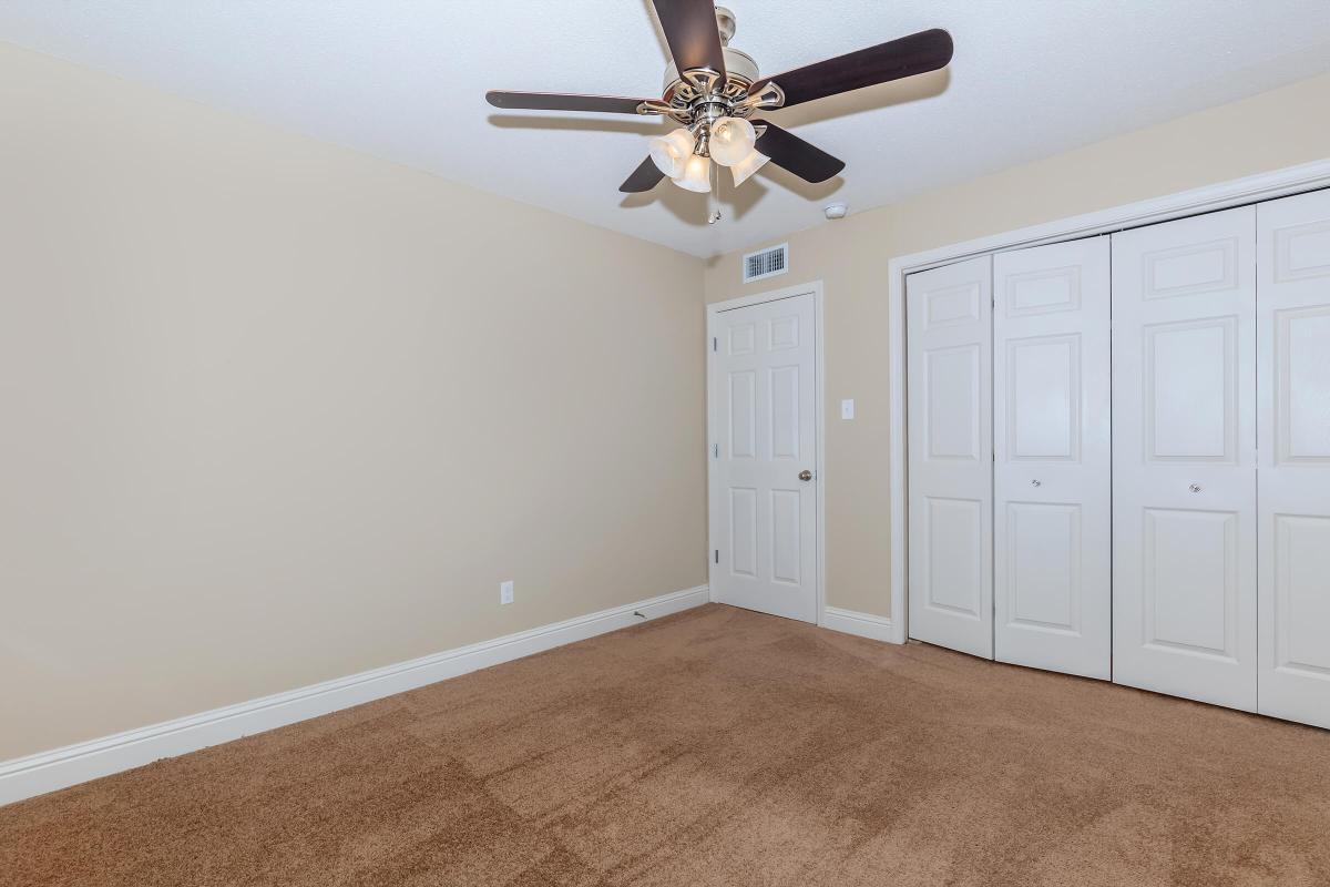 SPACIOUS BEDROOM WITH CARPETING.