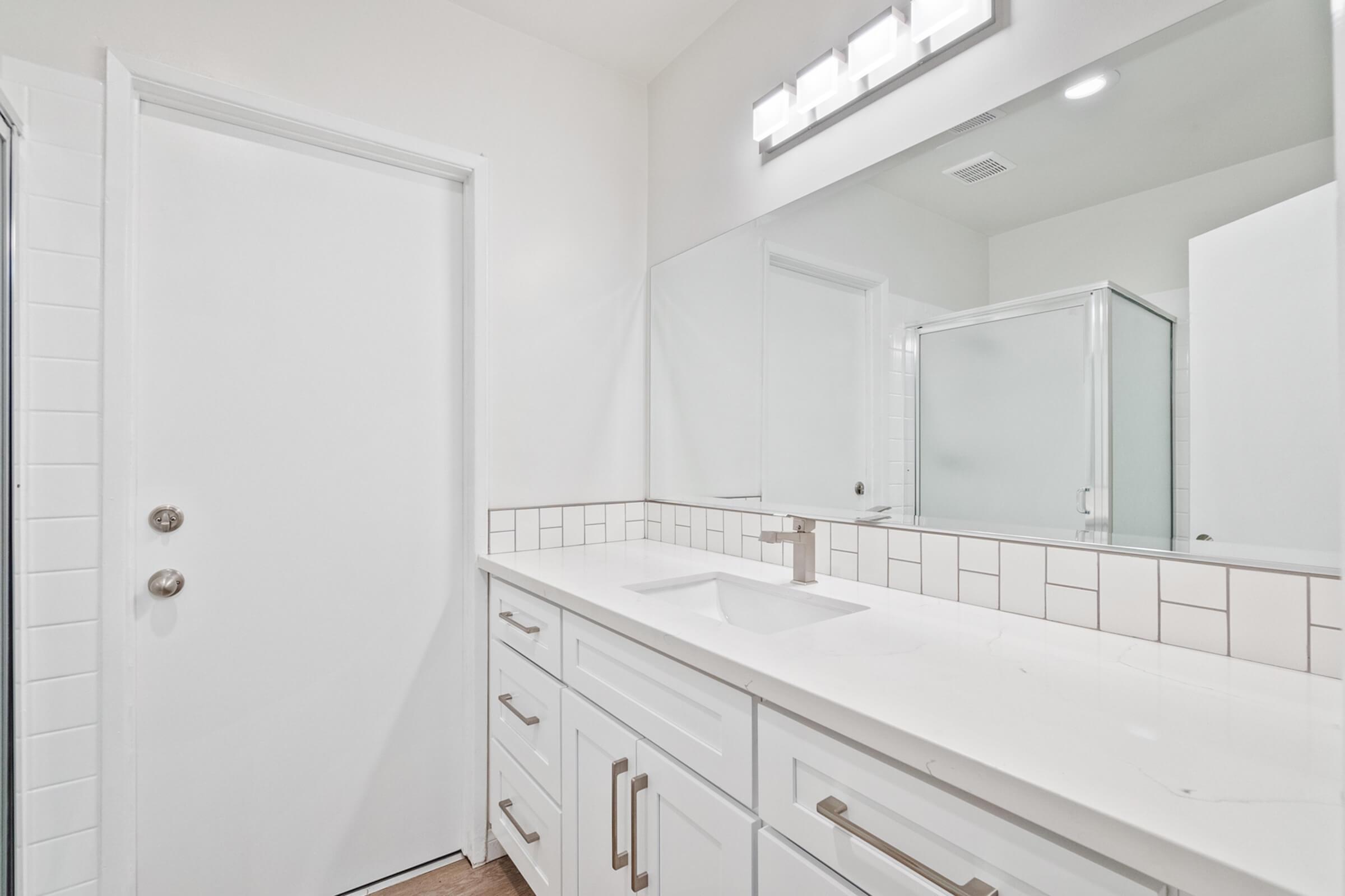 a kitchen with a sink and a mirror