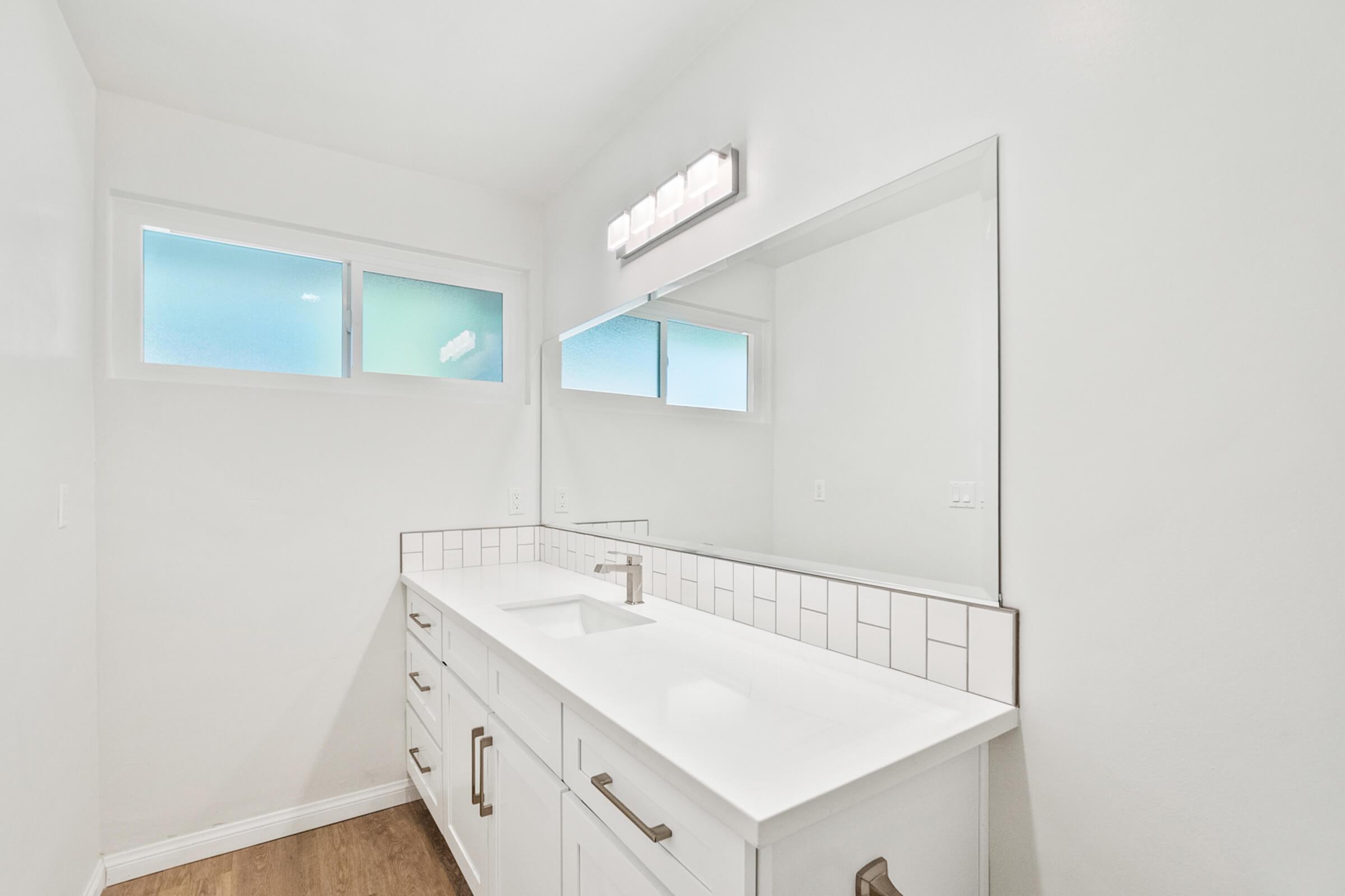 a kitchen with a sink and a mirror