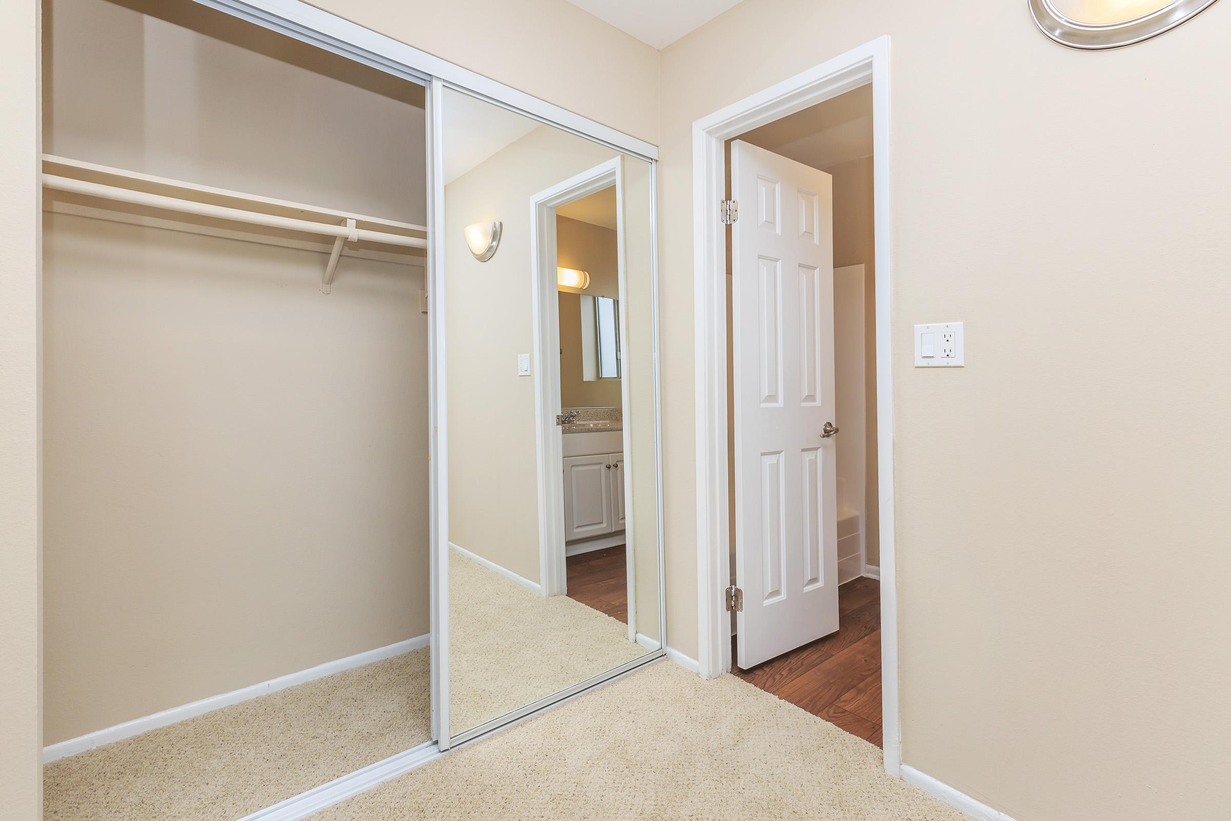 Open sliding mirror glass doors to closet